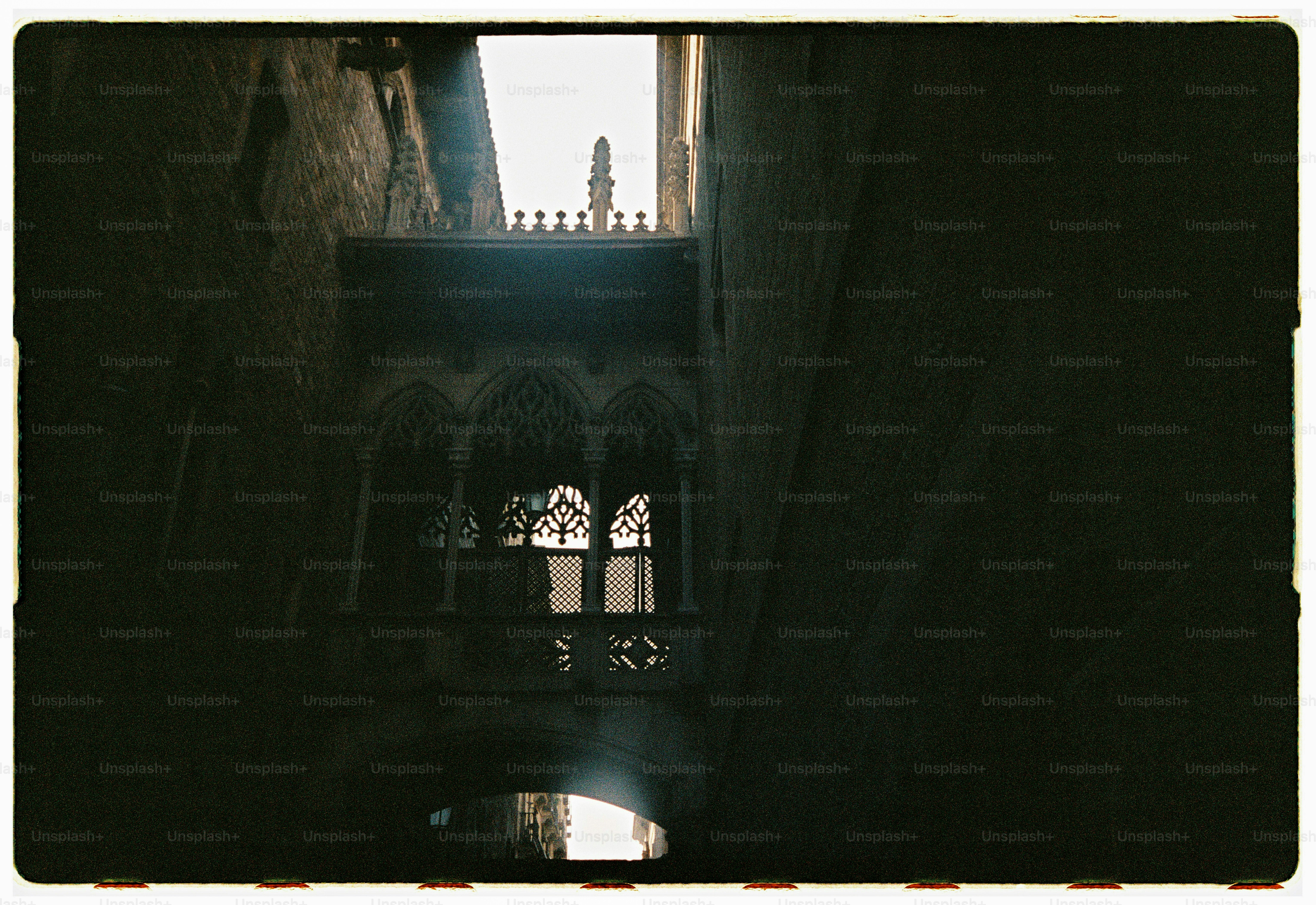 Gothic stone bridge between dark buildings - Photo on Unsplash+