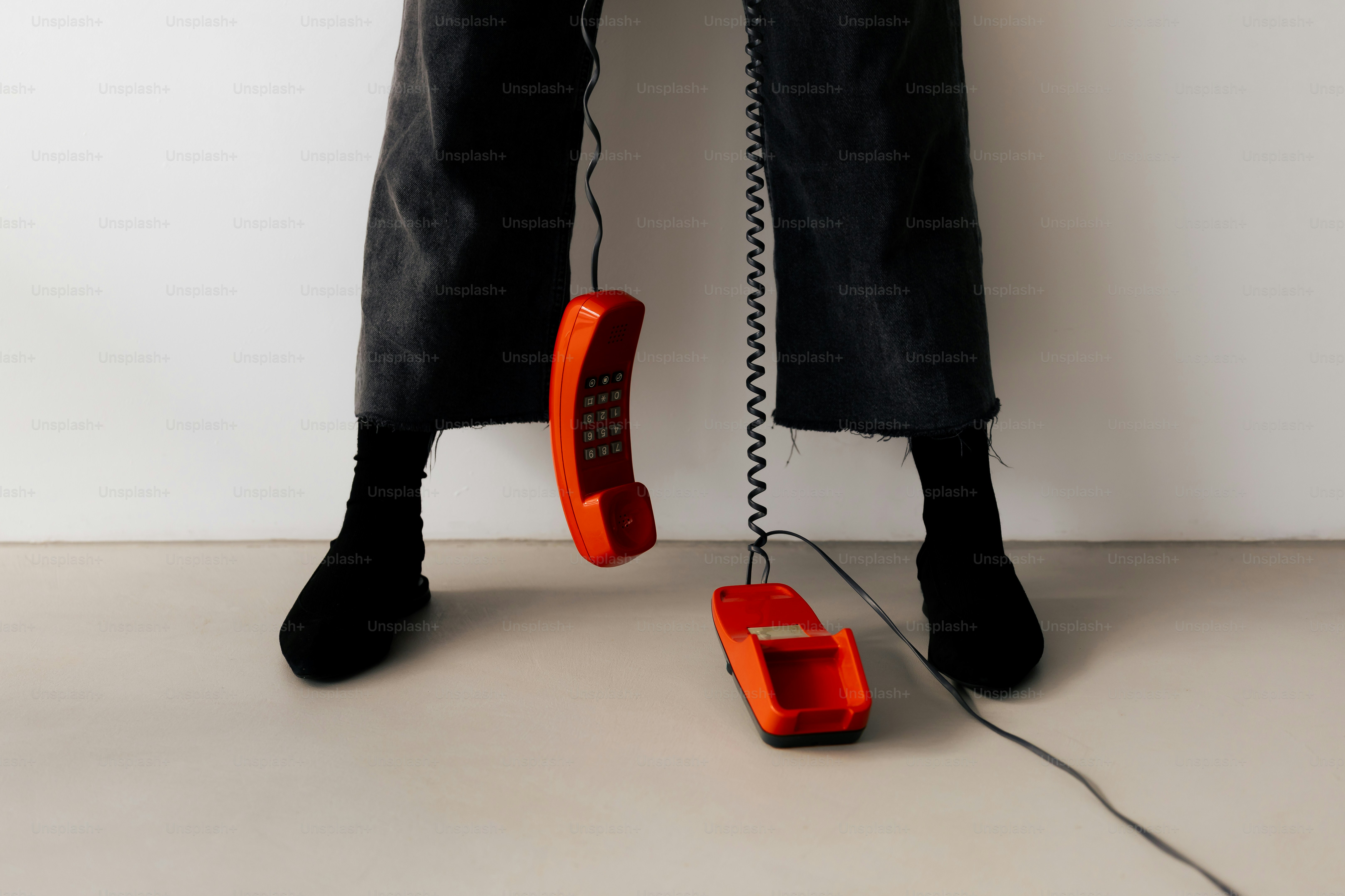 Person with red landline telephone - Photo on Unsplash+