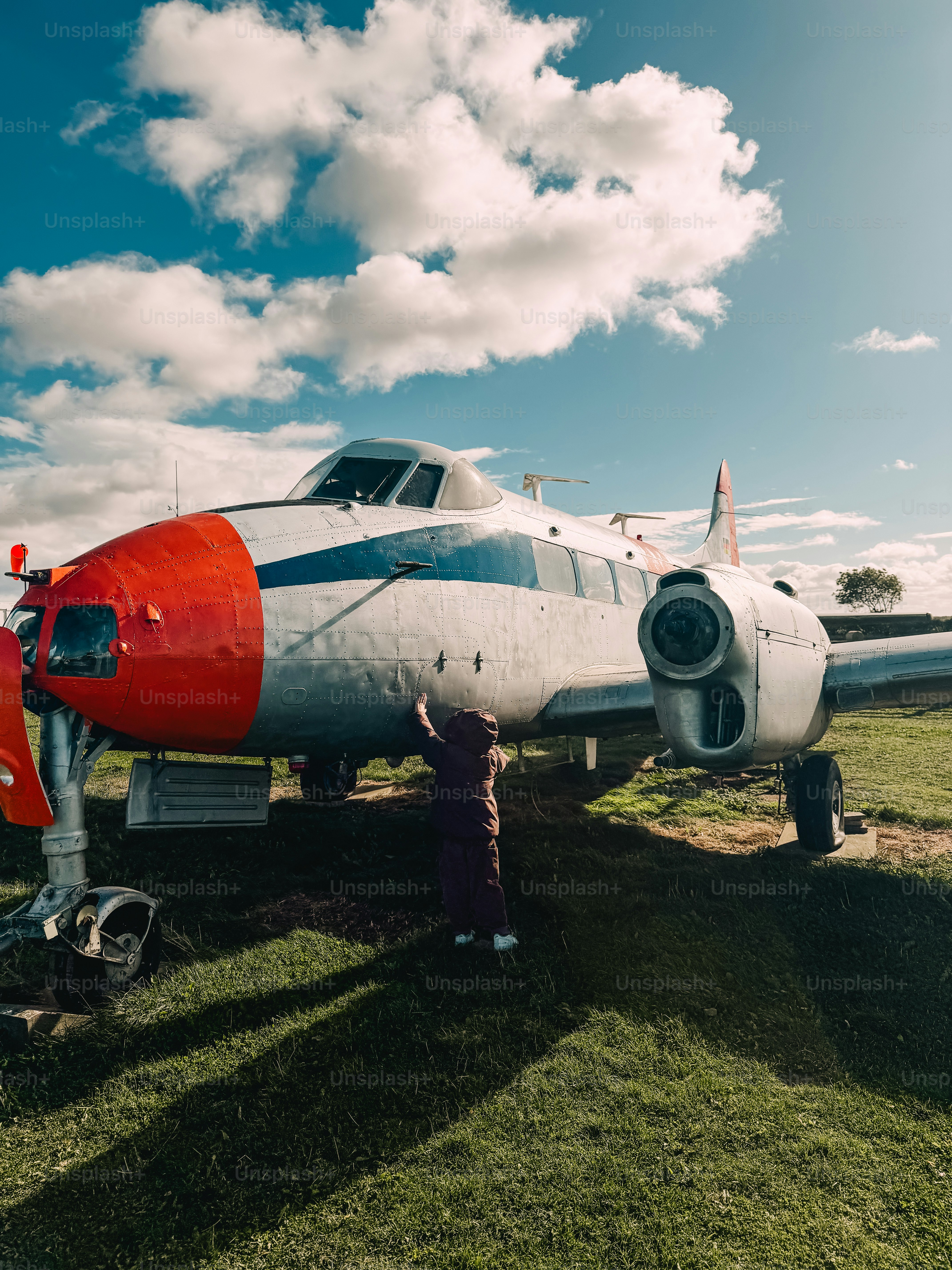 Persona tocando el fuselaje de un avión antiguo - Foto en Unsplash+
