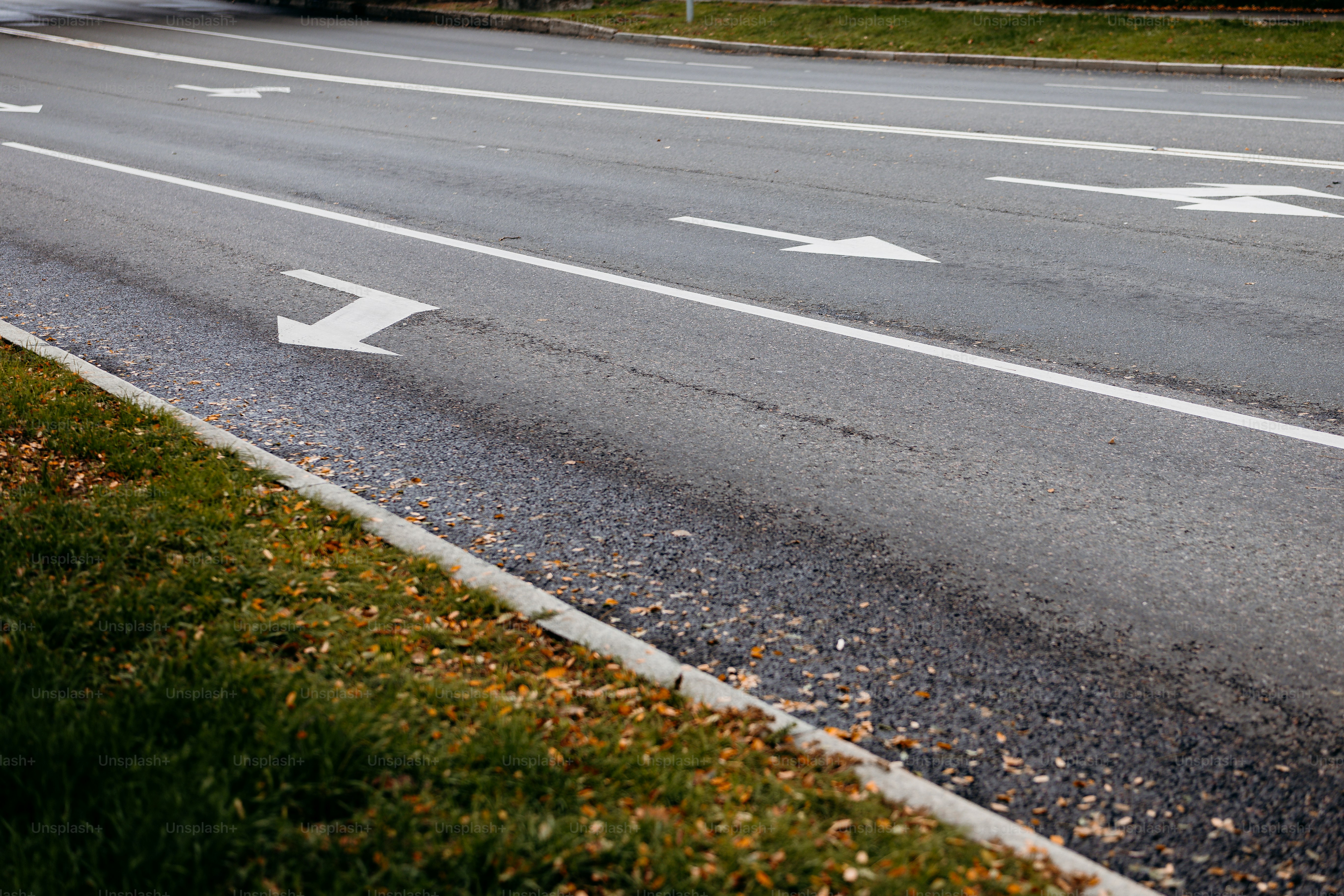 Directional arrows on asphalt road - Photo on Unsplash+