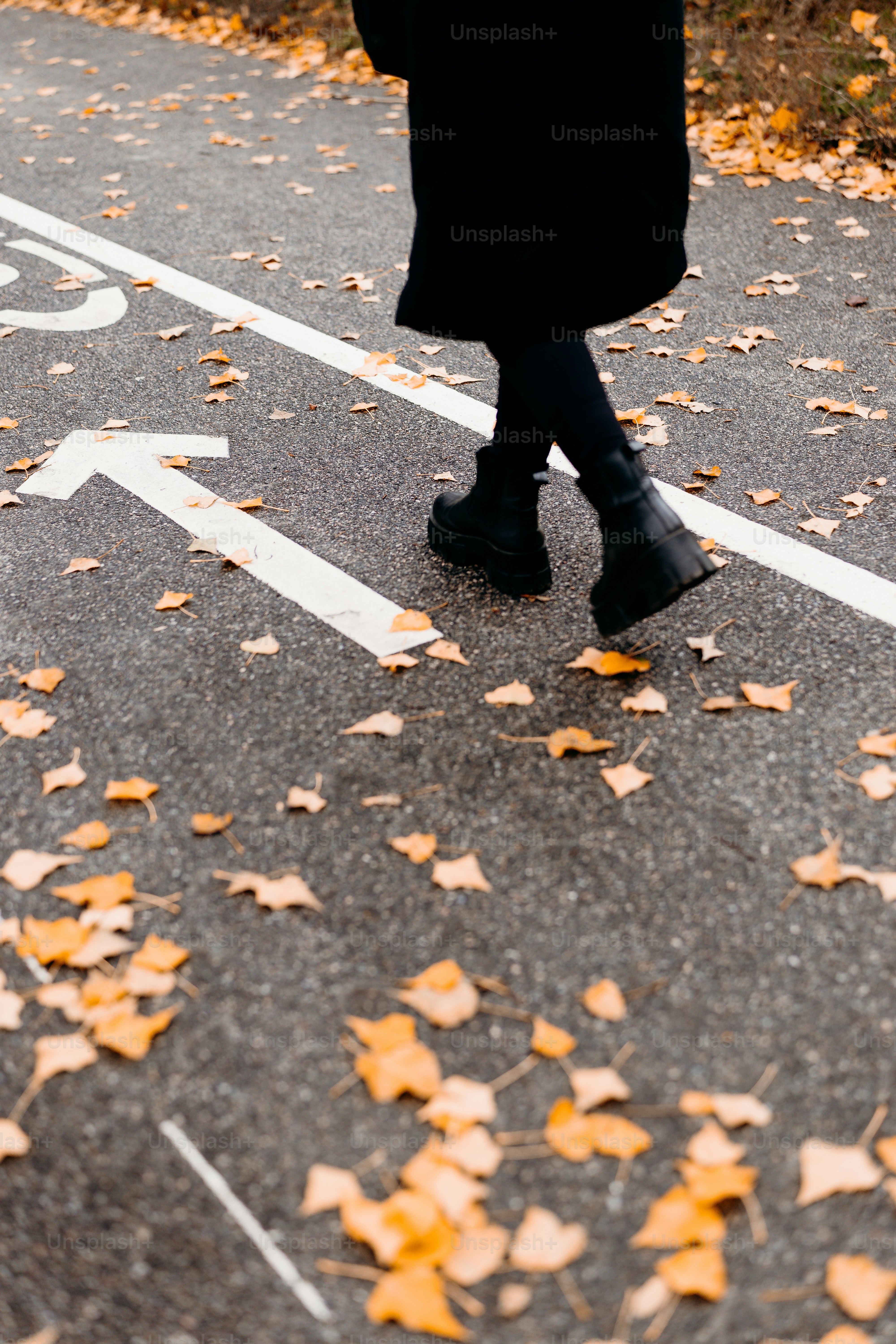 Person walking on autumn path - Photo on Unsplash+