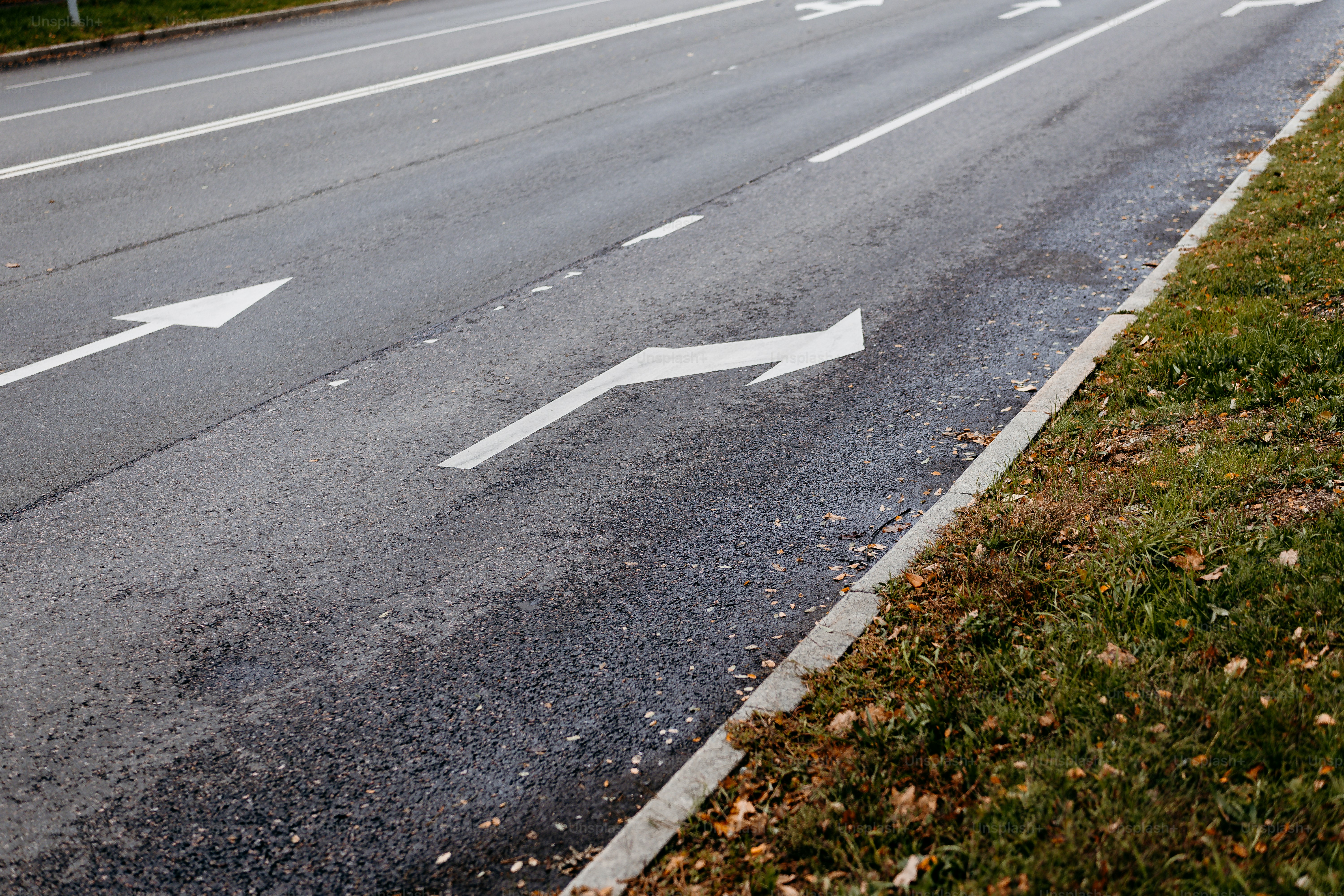 Directional arrows on asphalt road - Photo on Unsplash+