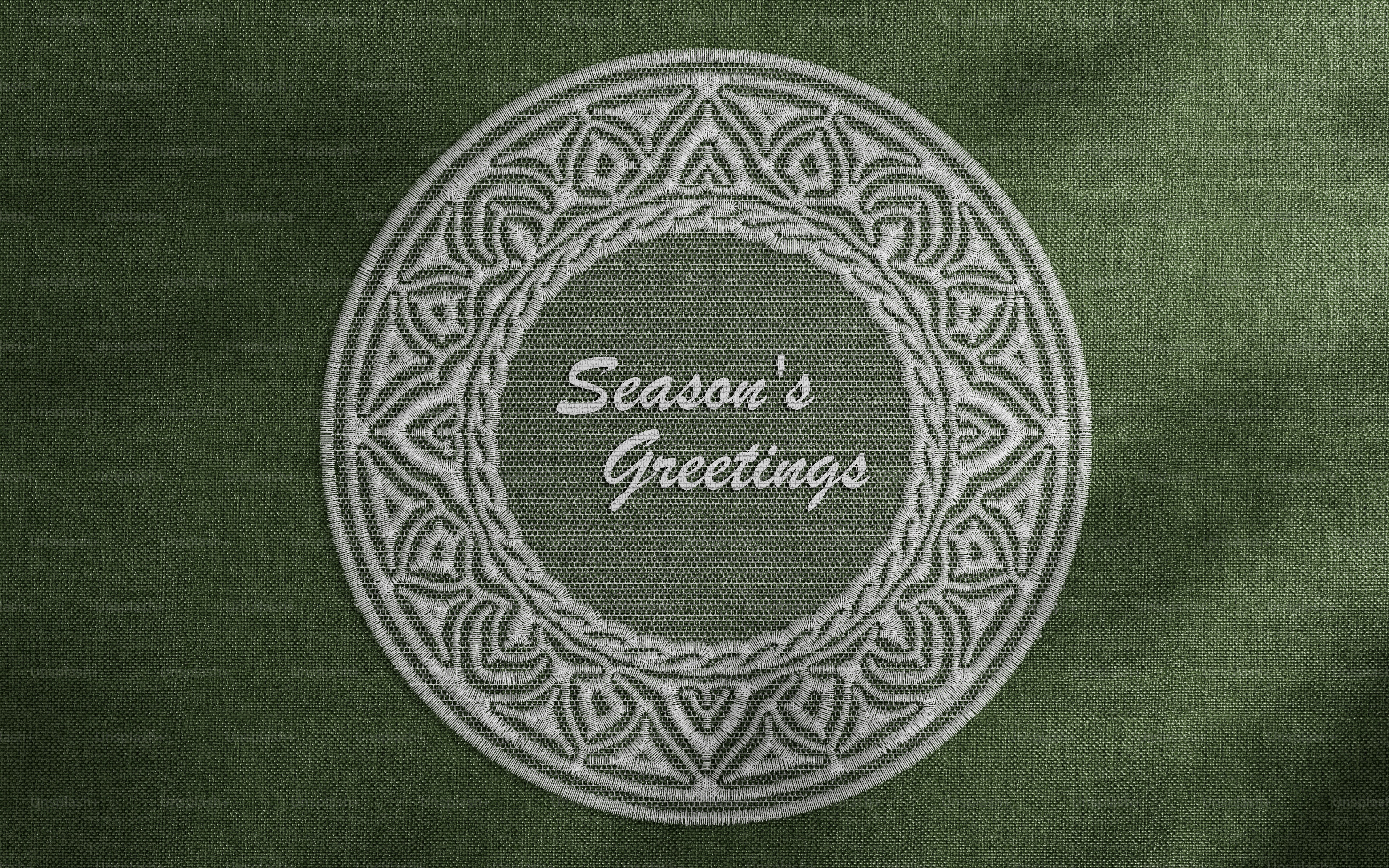 A white lace doily with a circular pattern on a dark green textured fabric background