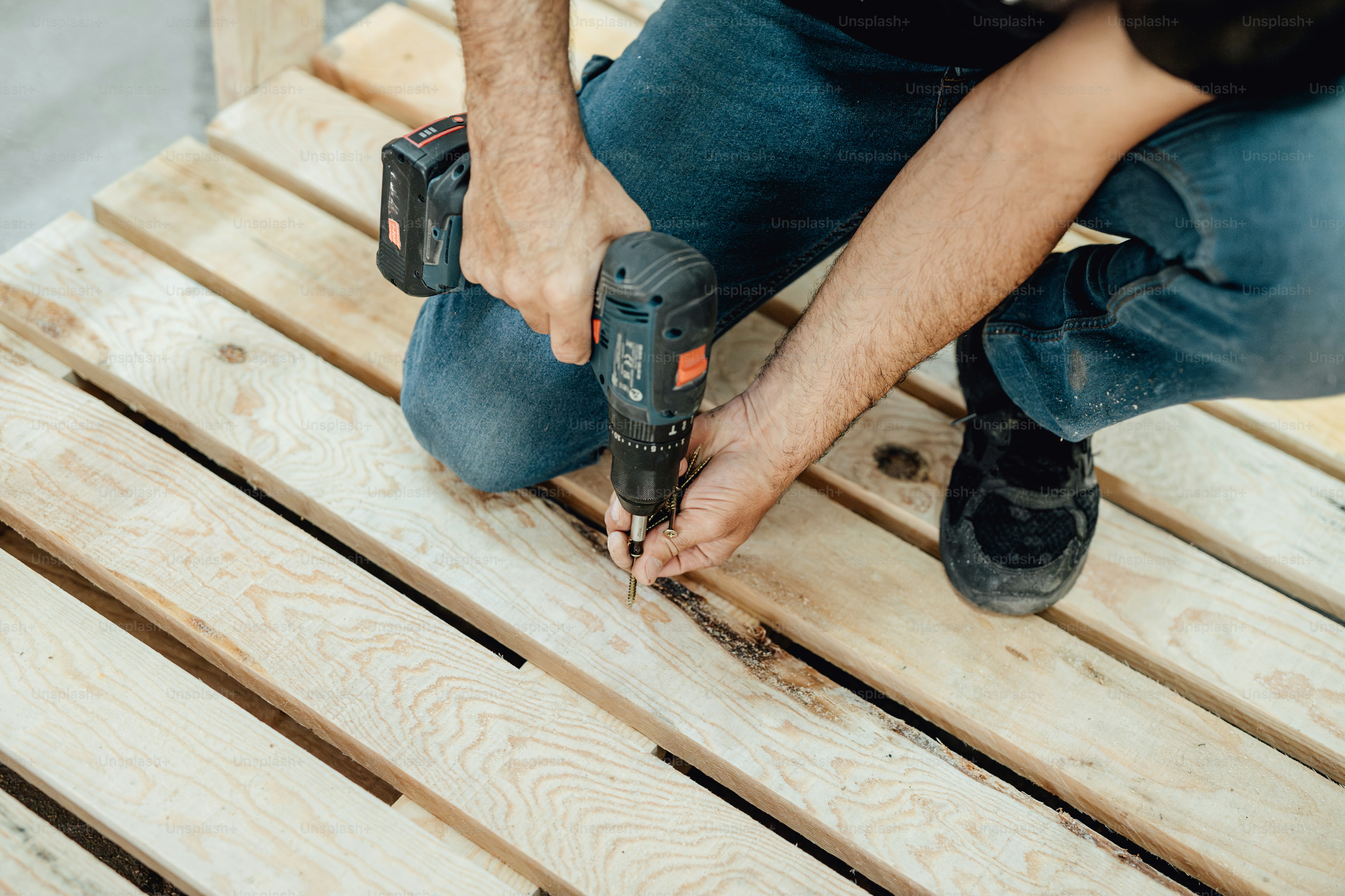 Person using drill on wooden structure - Photo on Unsplash+