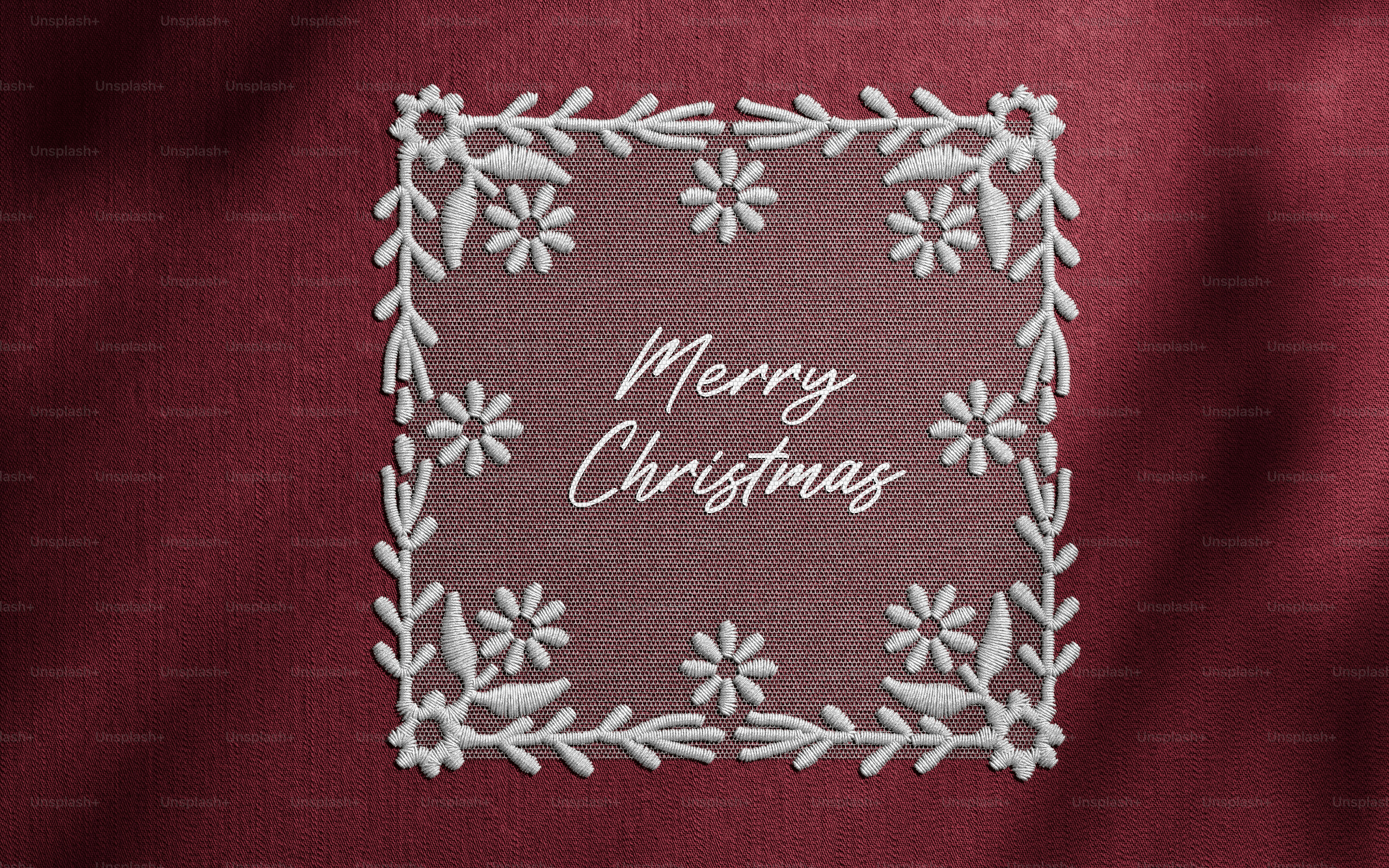 White floral lace embroidery framing the text Merry Christmas on a deep red fabric background