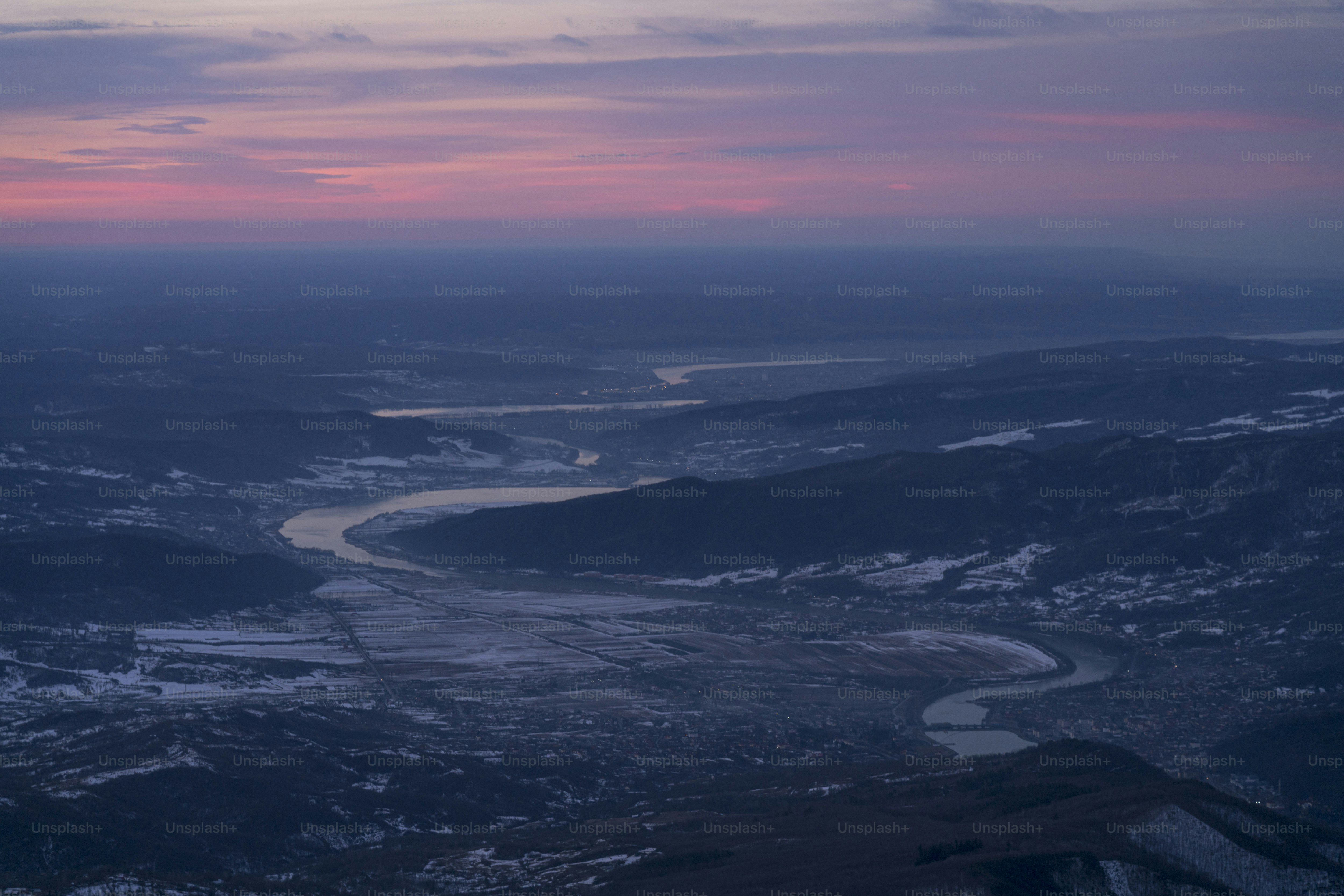 Winding river in snowy valley - Photo on Unsplash+