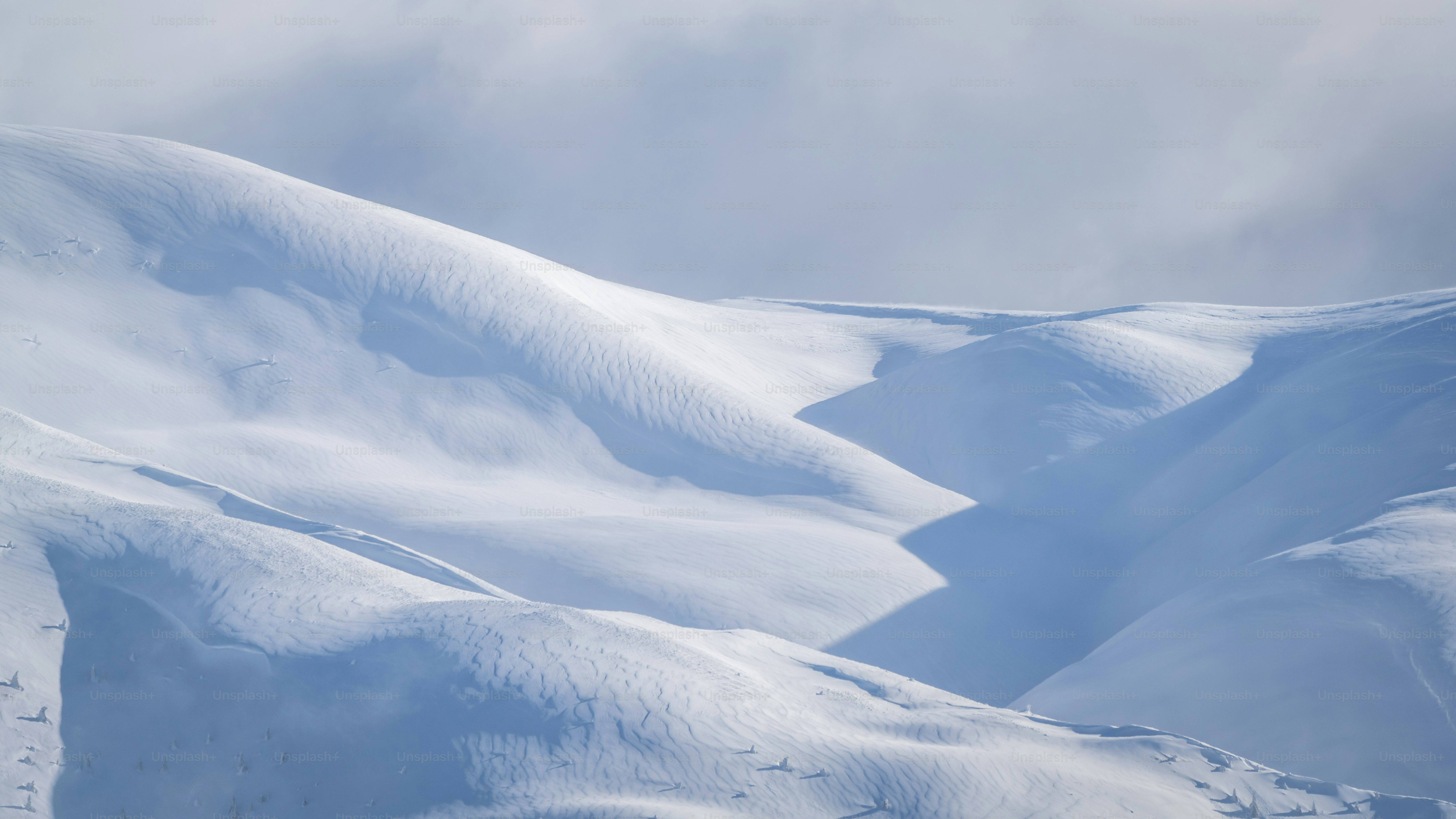 Snowy mountain slopes with shadows - Photo on Unsplash+