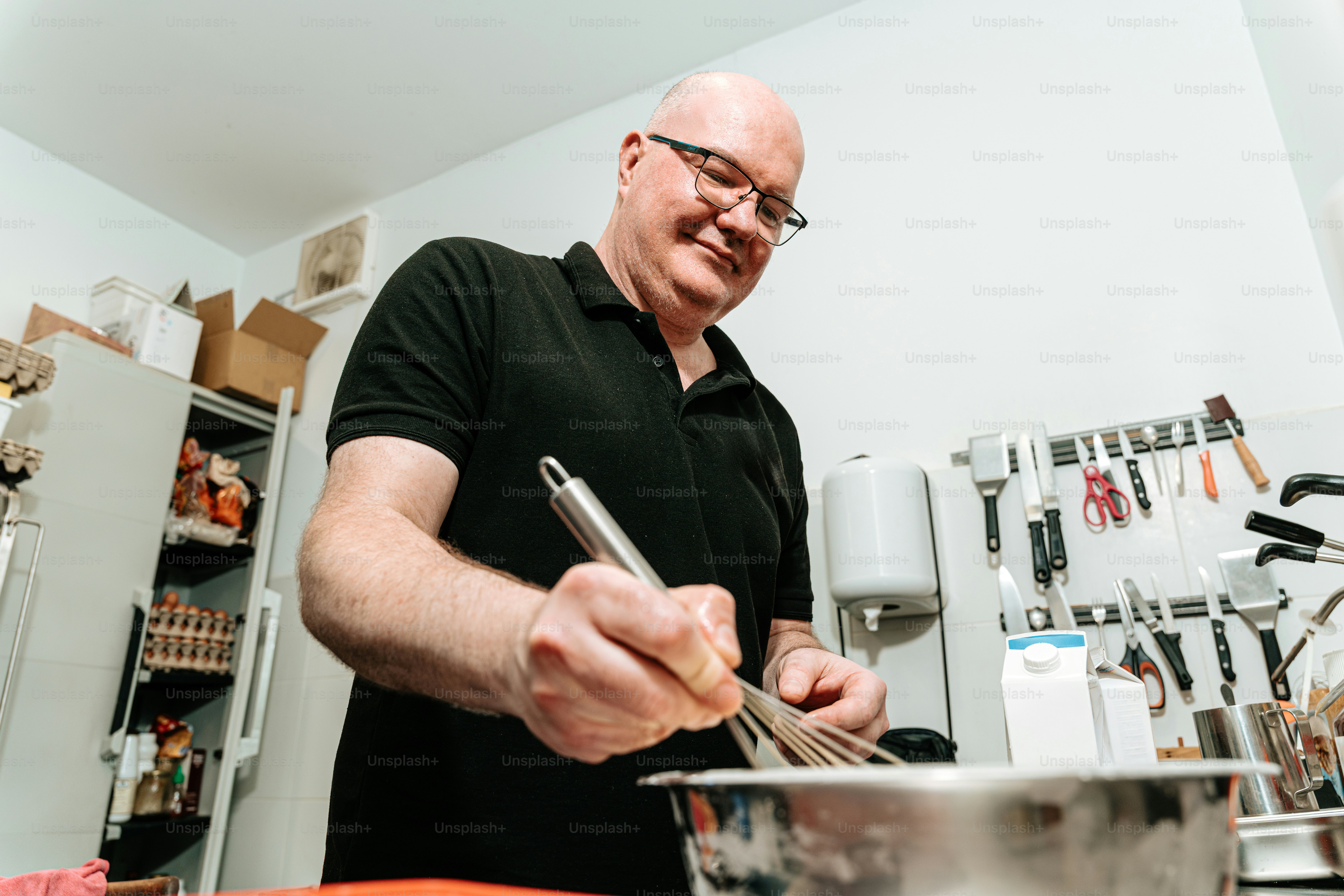 Man whisking ingredients in kitchen - Photo on Unsplash+