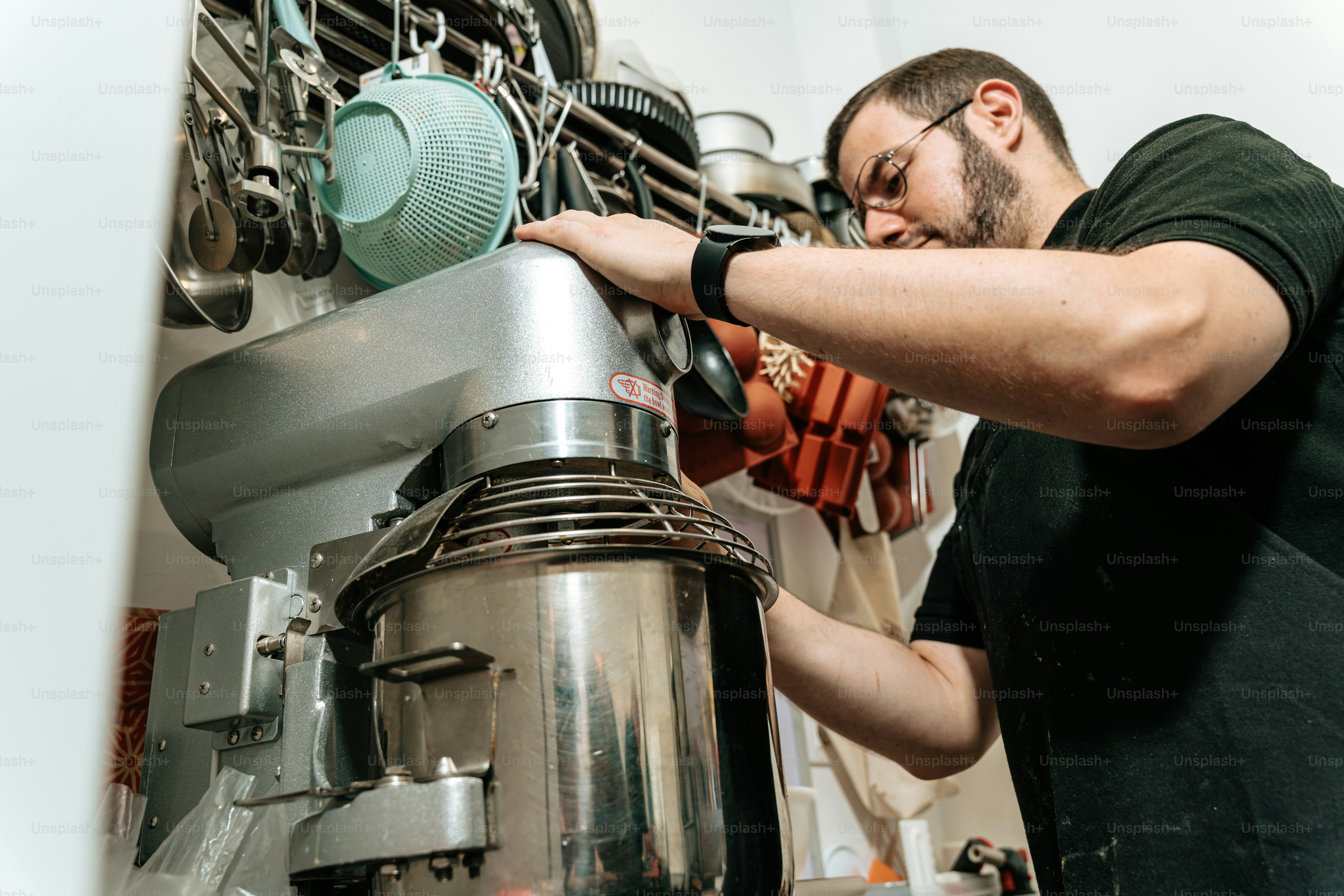 Man operating industrial stand mixer - Photo on Unsplash+