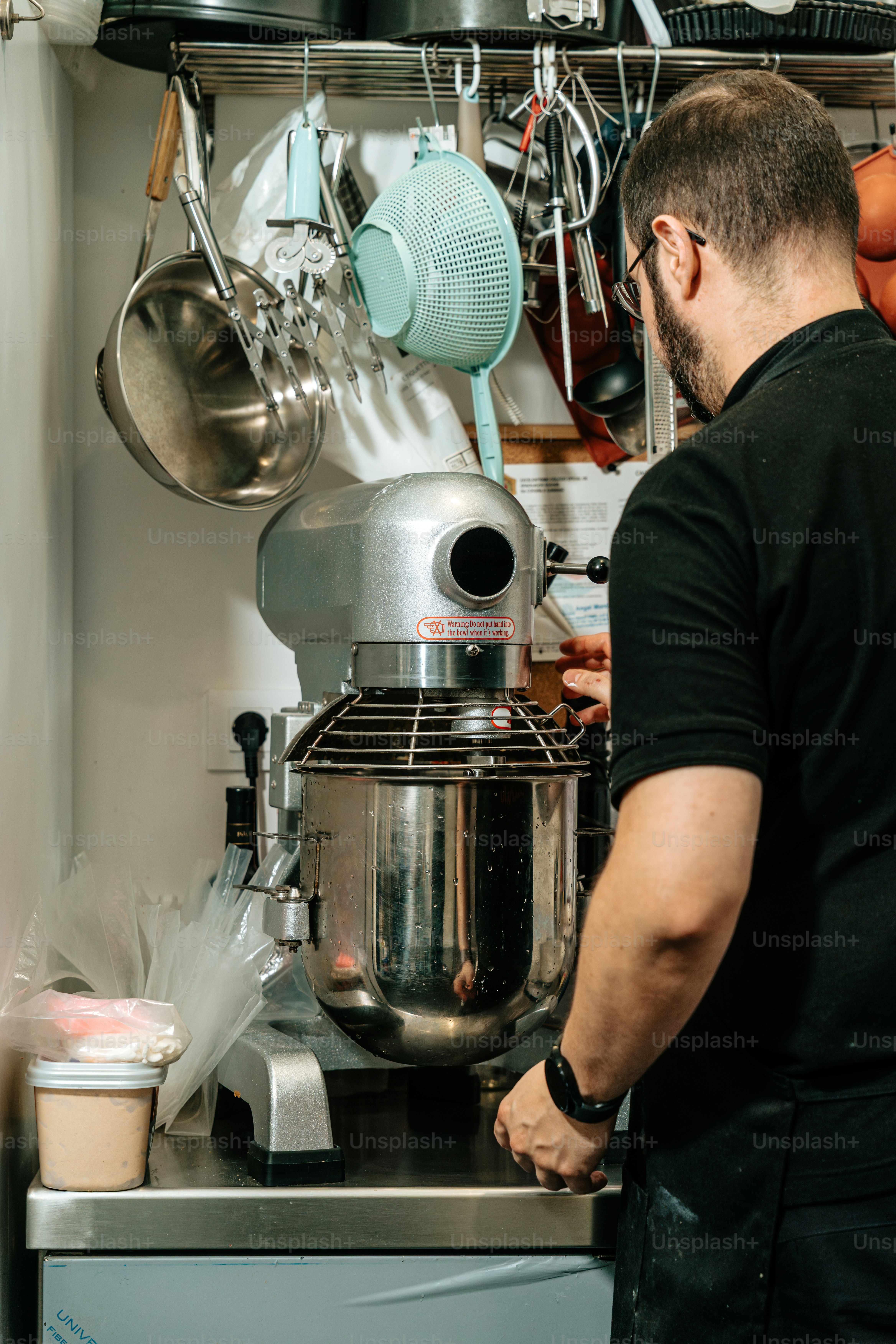 Man operating industrial stand mixer - Photo on Unsplash+