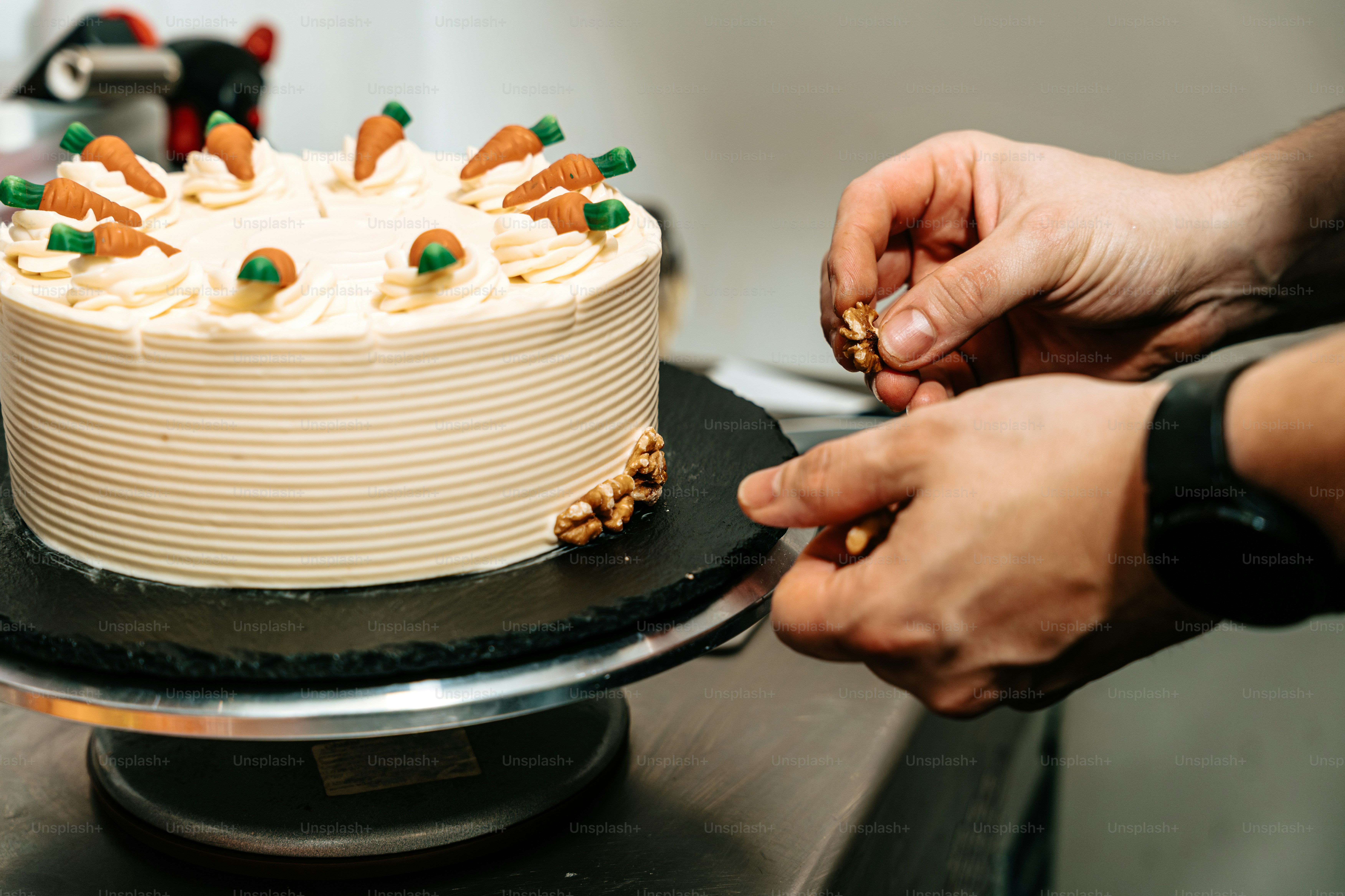 Person decorating carrot cake with walnuts - Photo on Unsplash+