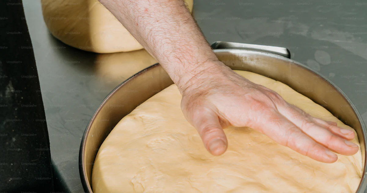 Normal Crust Person pressing dough into baking pan - Photo on Unsplash+
