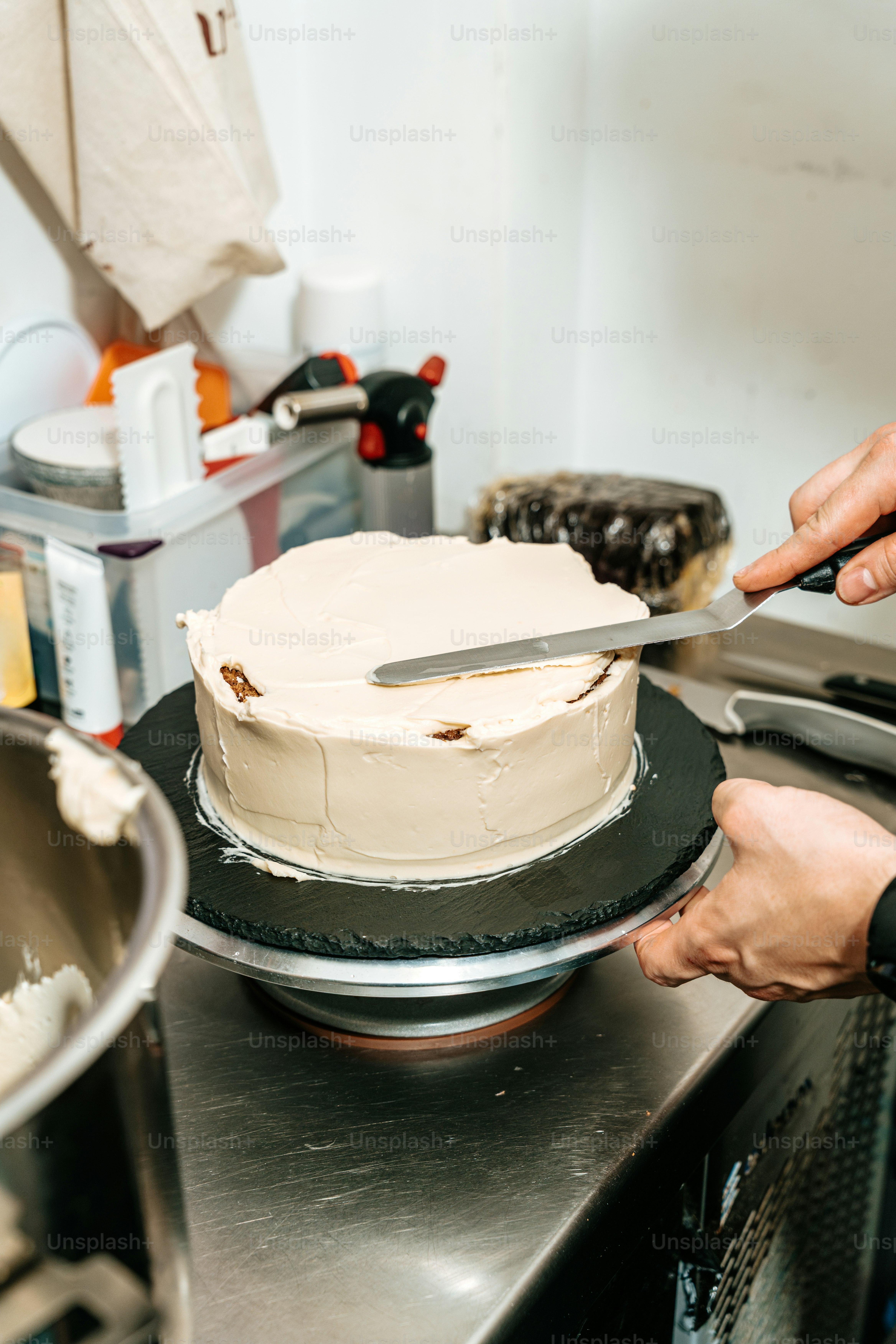 Person frosting cake with metal spatula - Photo on Unsplash+