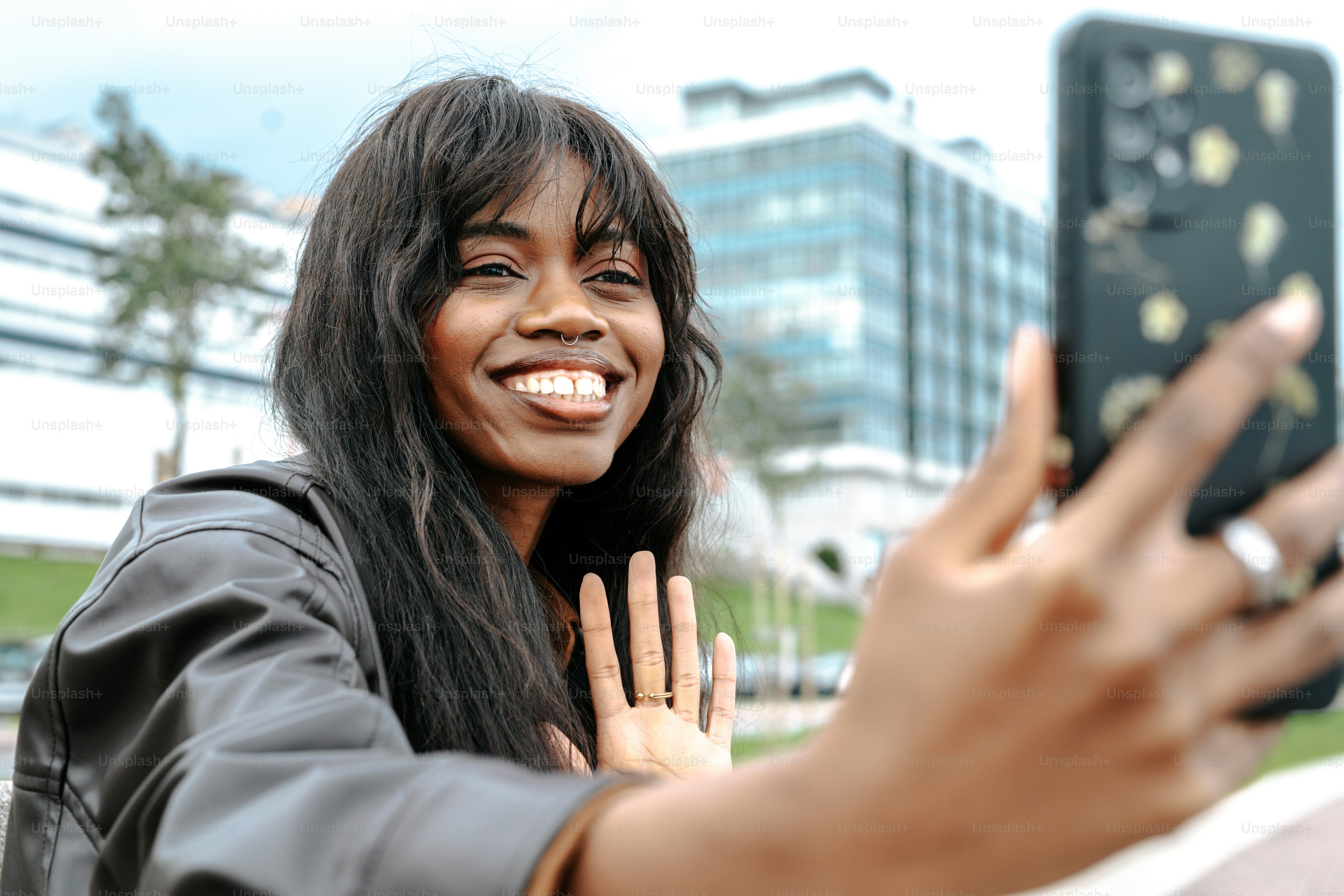 Smiling woman using smartphone in jacket - Photo on Unsplash+