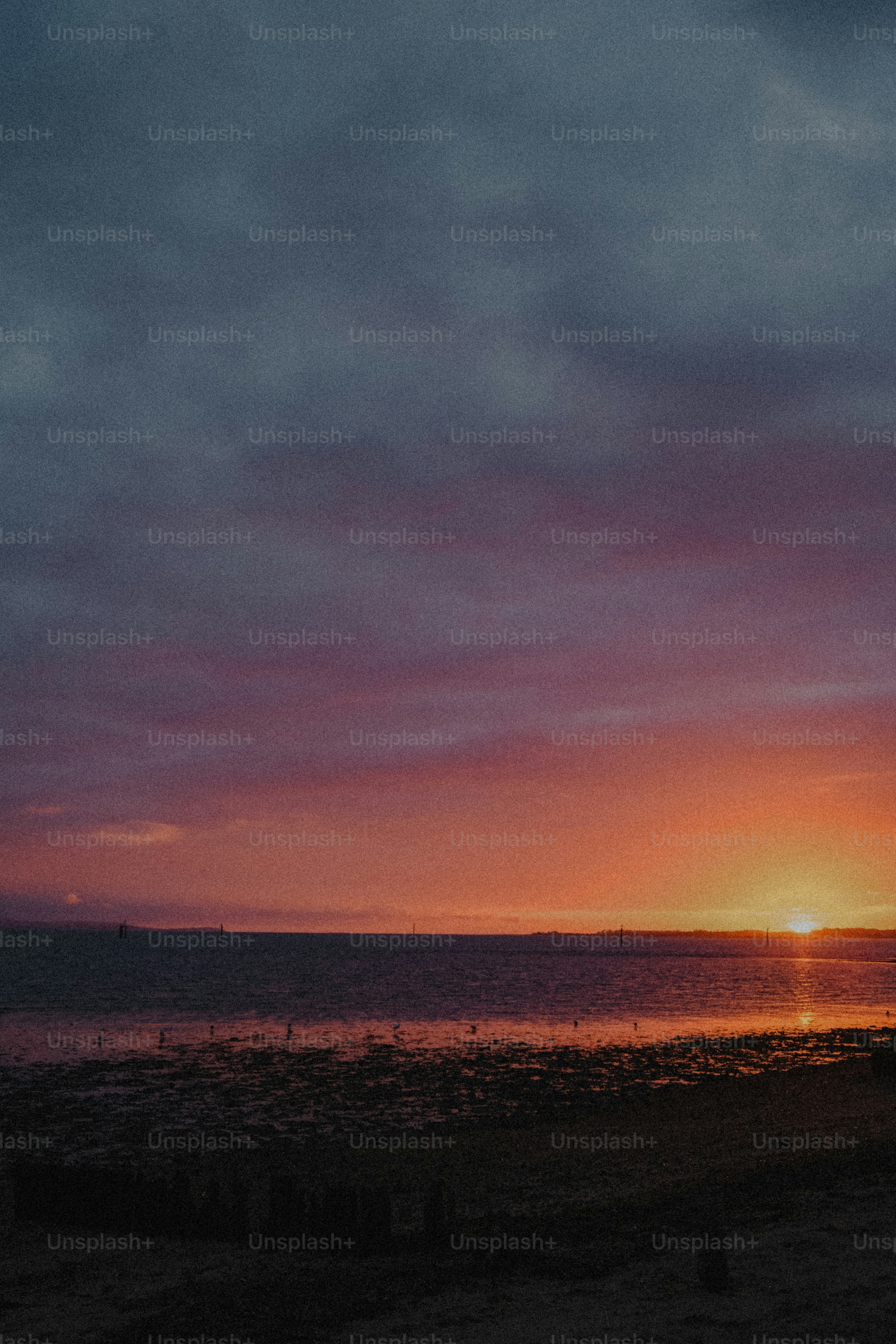 Low sun over a calm sea with a dark purple and orange sky