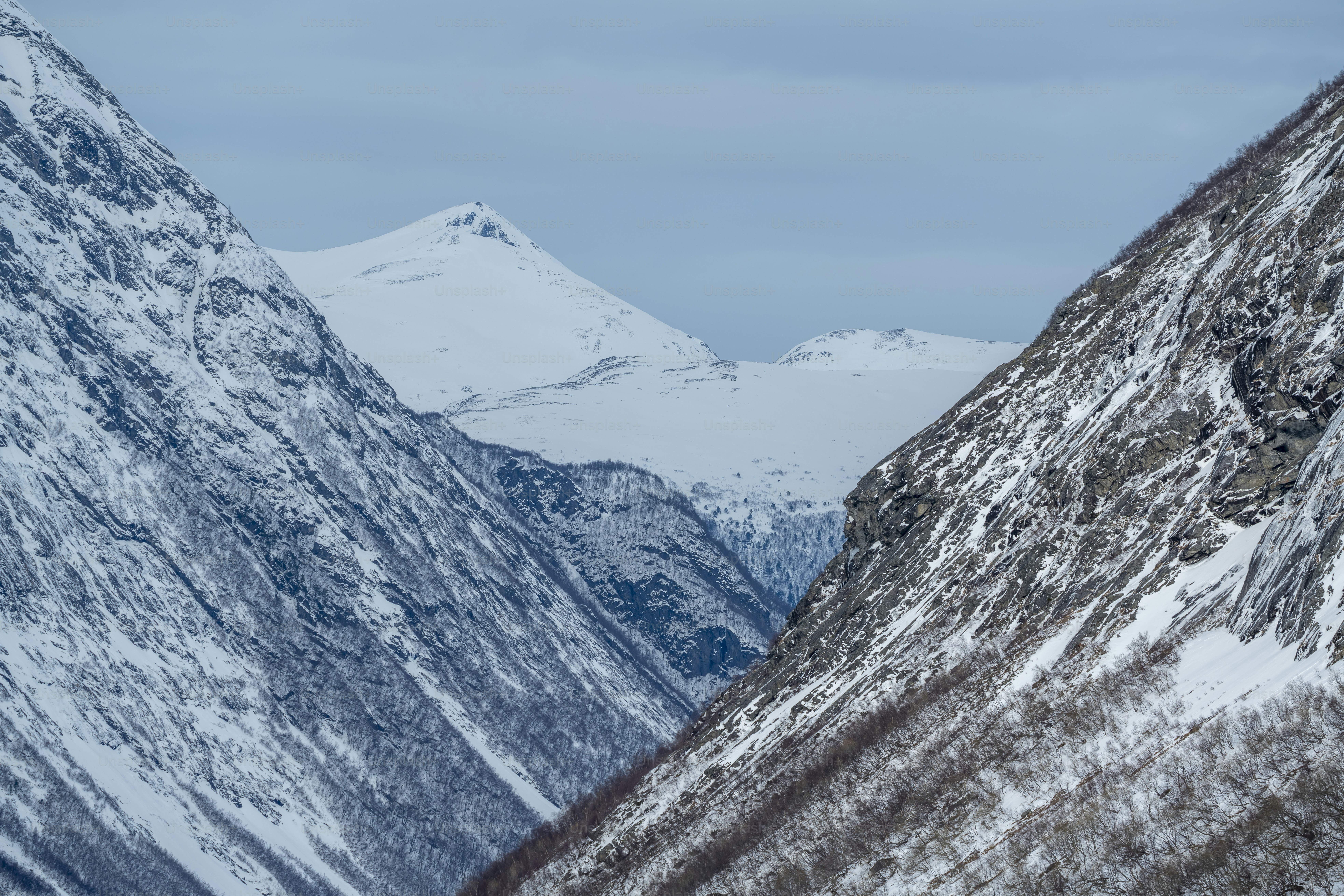 Snowy mountain peaks above valley - Photo on Unsplash+