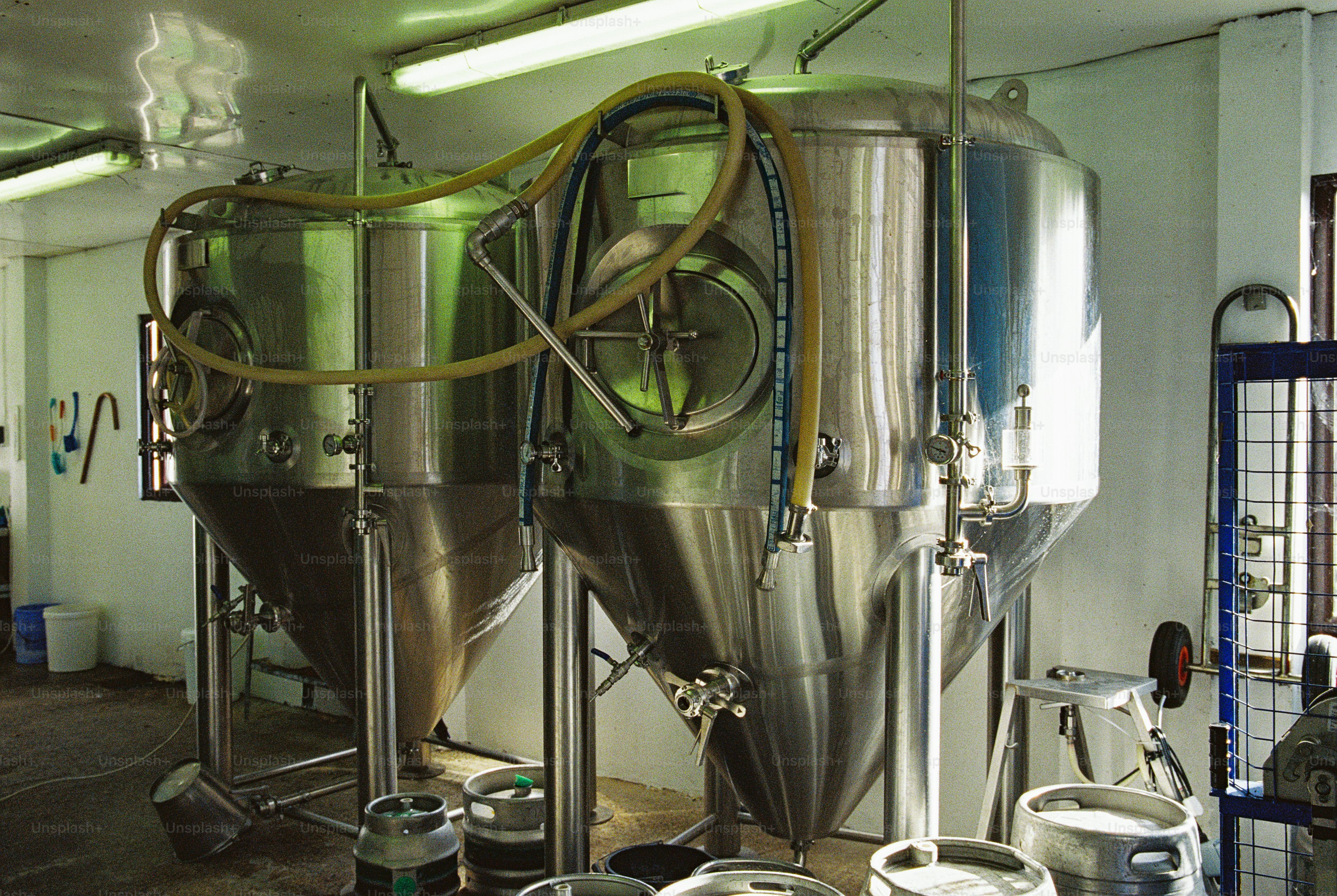 Stainless steel fermentation vessels in brewery - Photo on Unsplash+