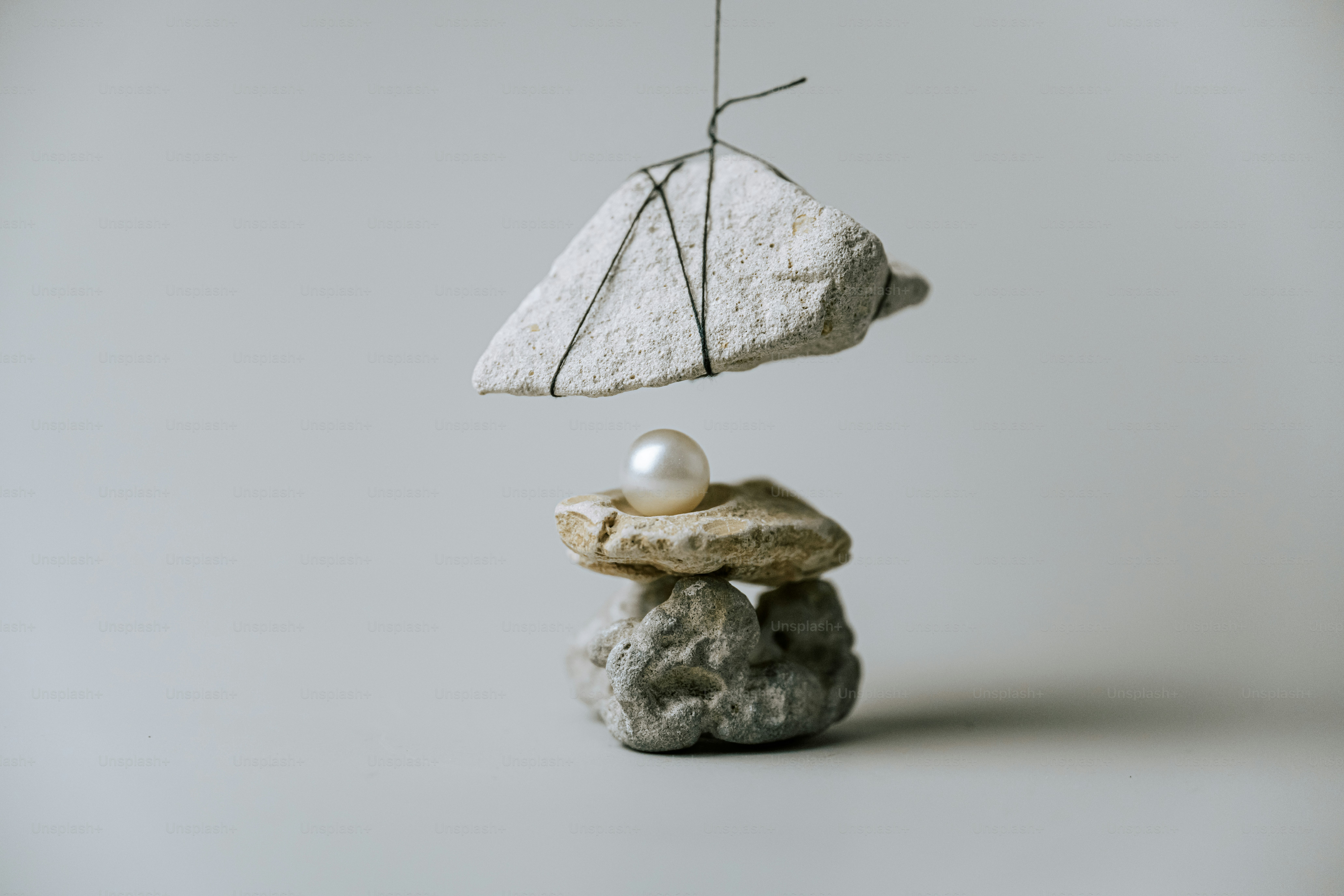 White pearl on stacked stones - Photo on Unsplash+