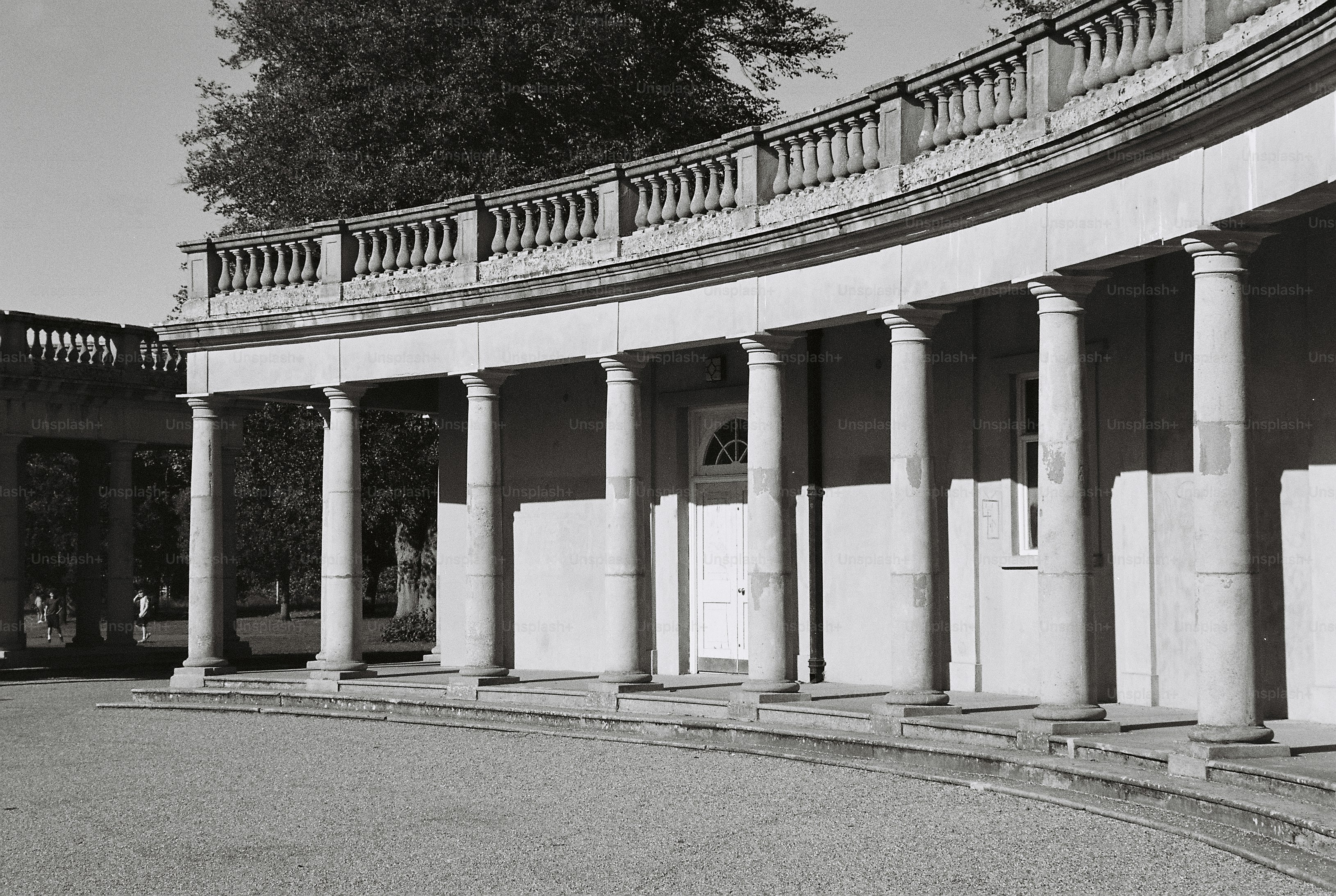 Curved stone colonnade with long shadows - Photo on Unsplash+