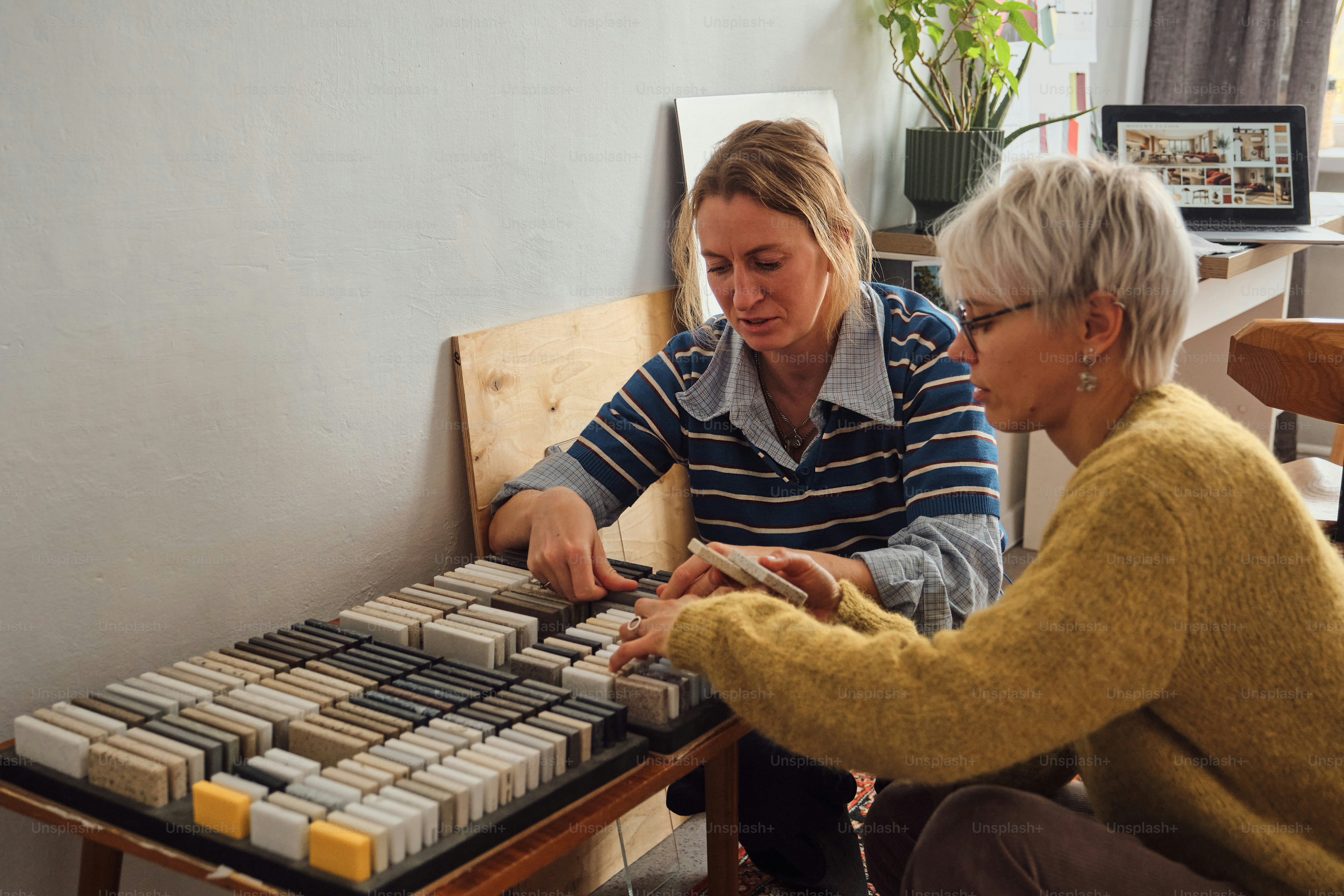 Women examining stone tile samples - Photo on Unsplash+