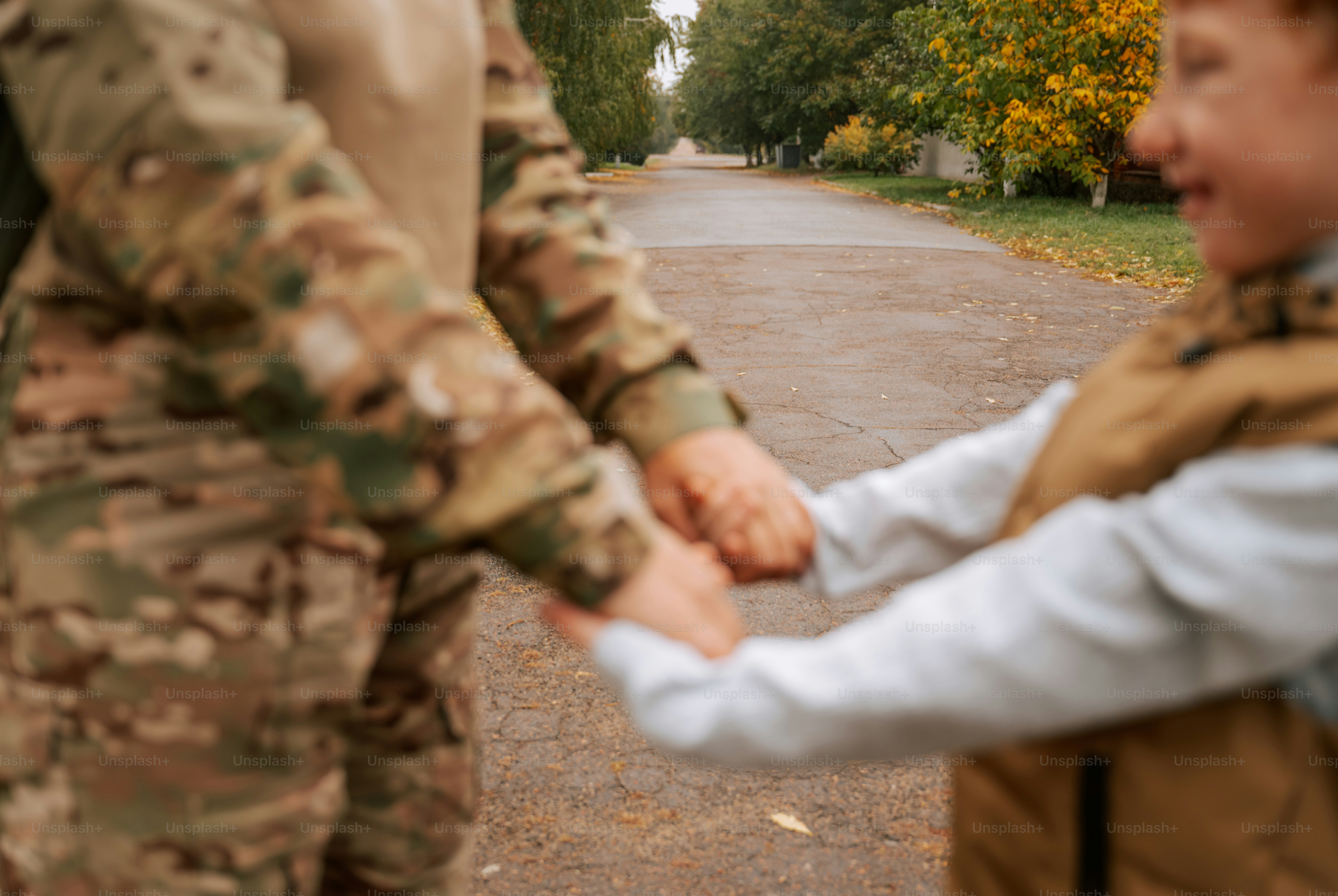 Person in camouflage holding child hand - Photo on Unsplash+