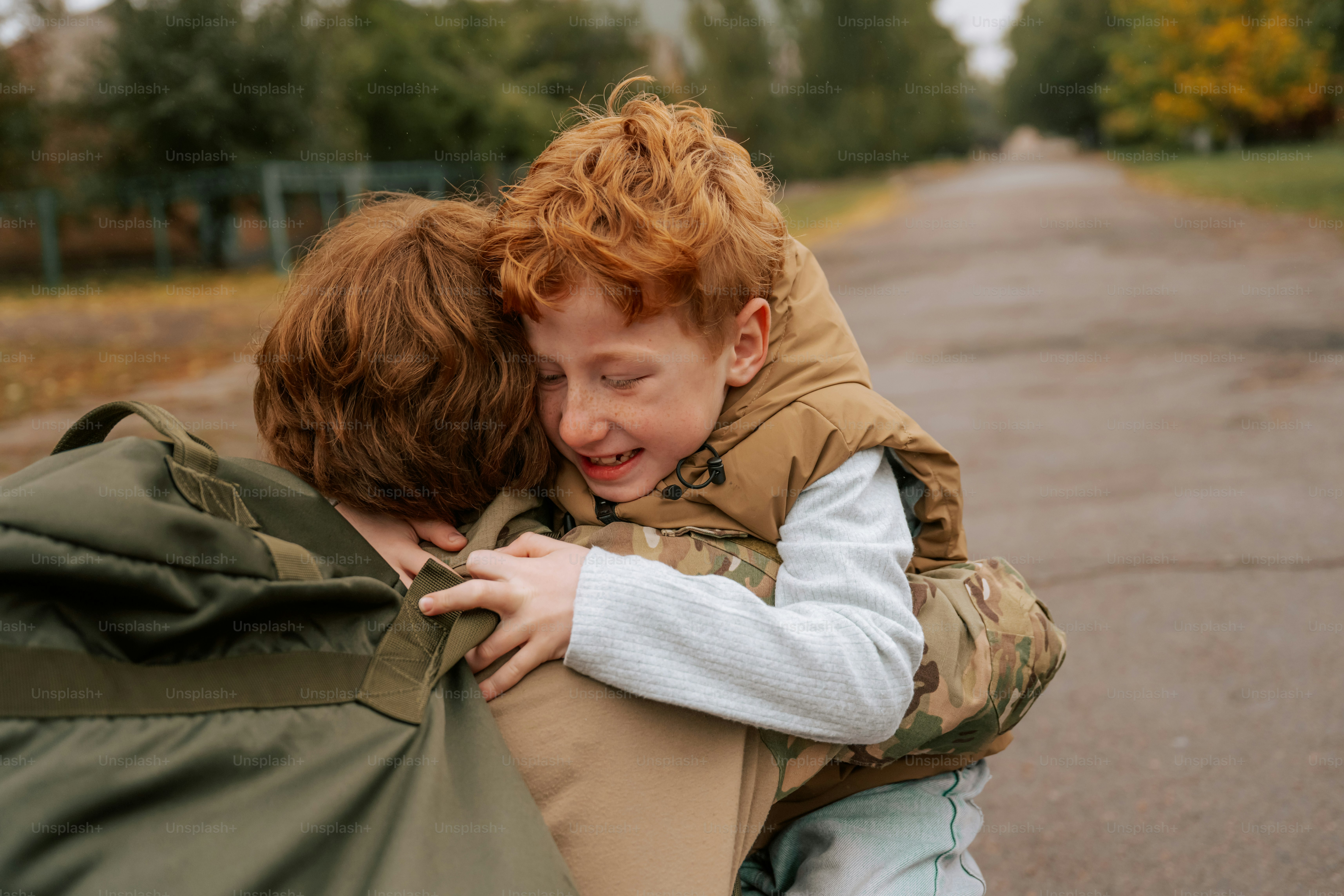 Child running toward adult in camouflage - Photo on Unsplash+