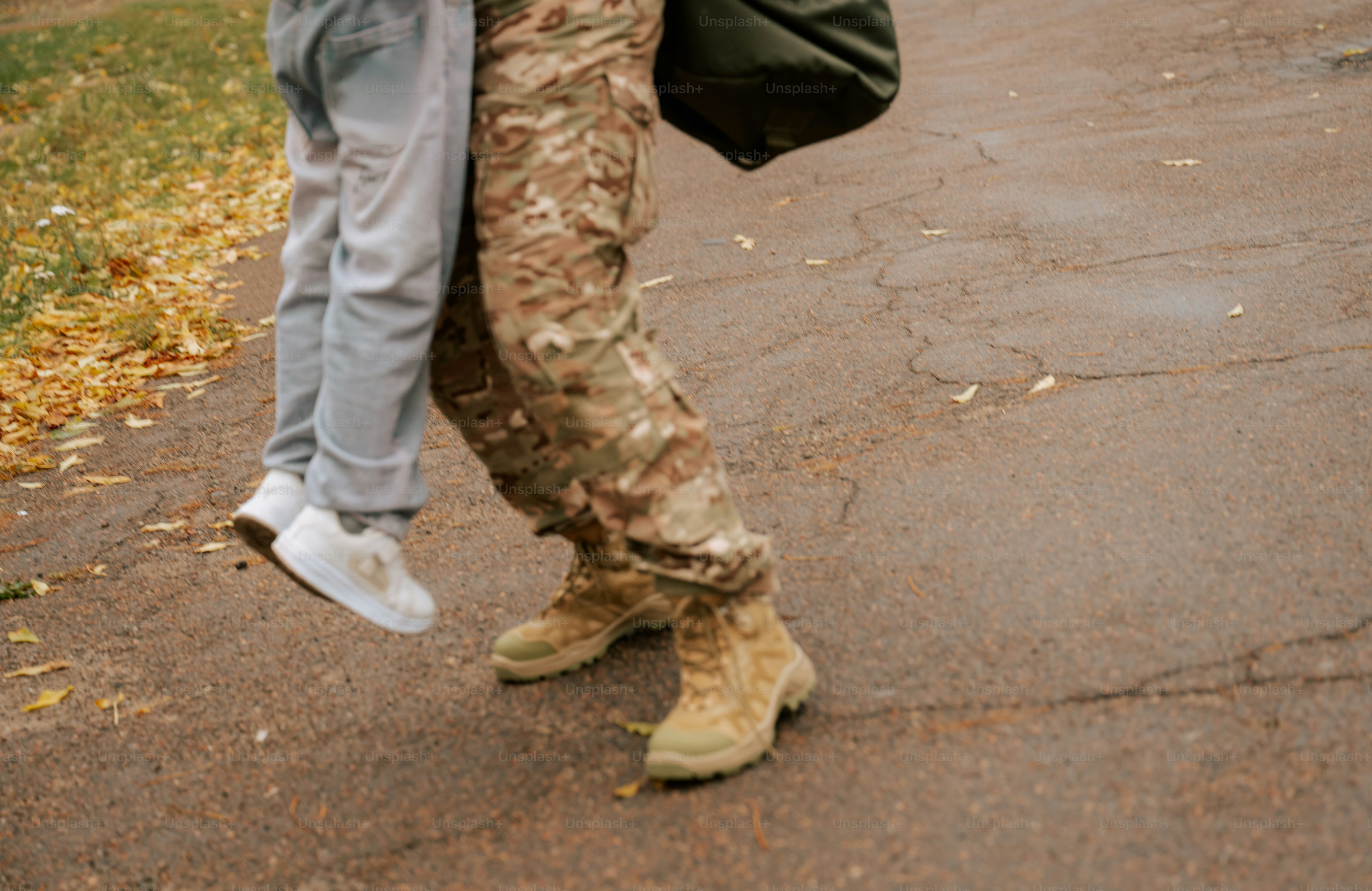 Child running toward adult in camouflage - Photo on Unsplash+