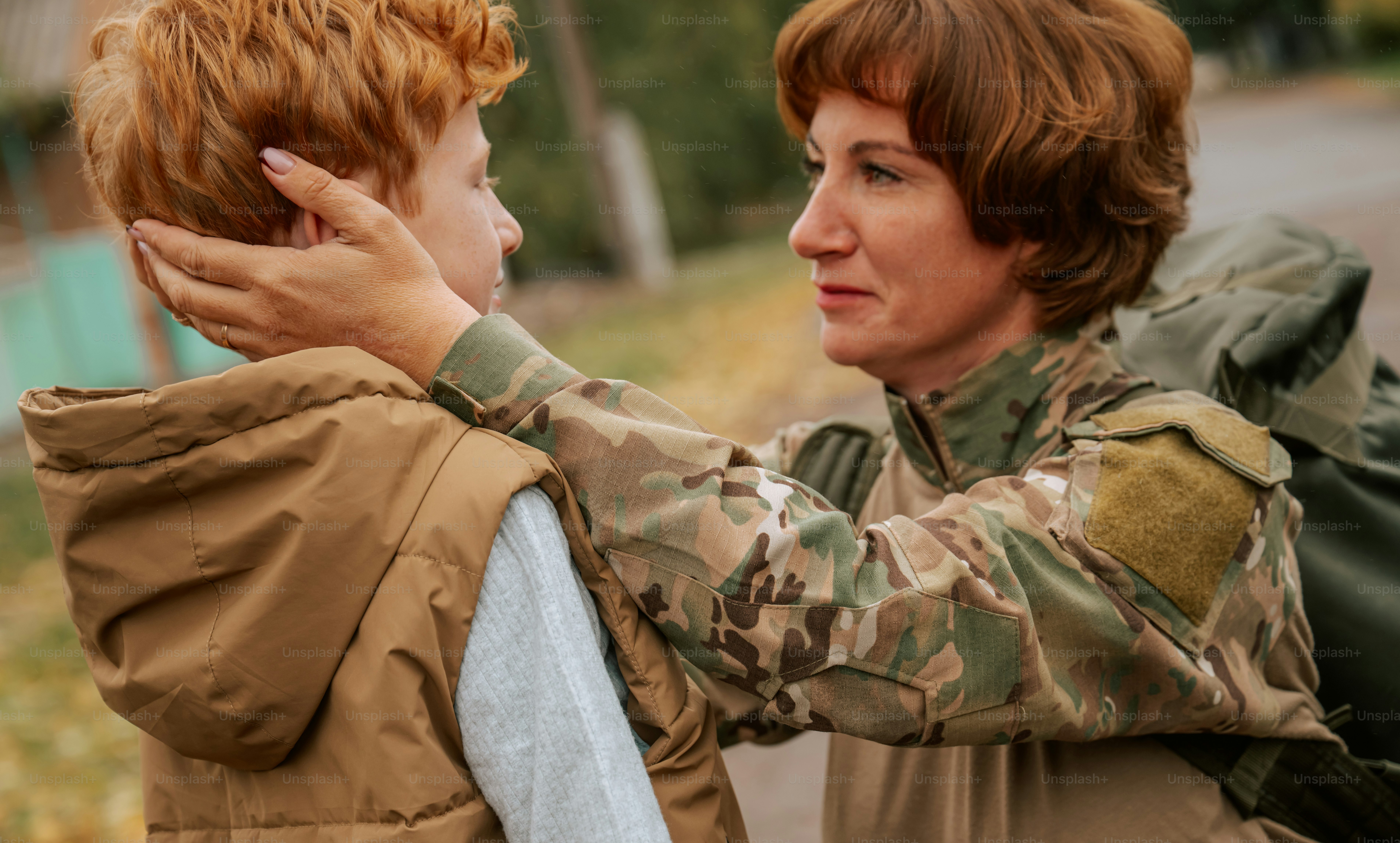 Woman in camouflage uniform holding child - Photo on Unsplash+
