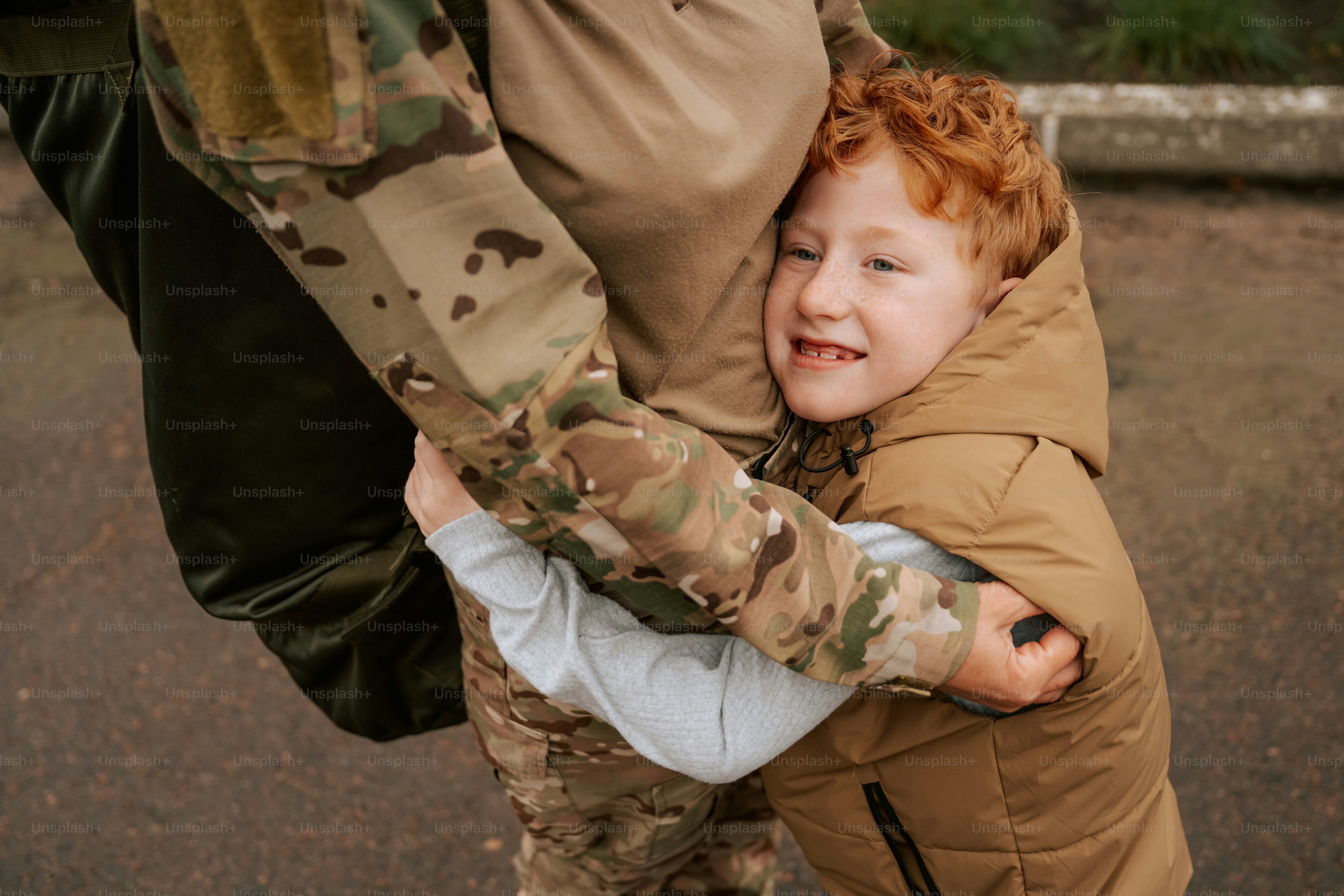 Child hugging person in military uniform - Photo on Unsplash+