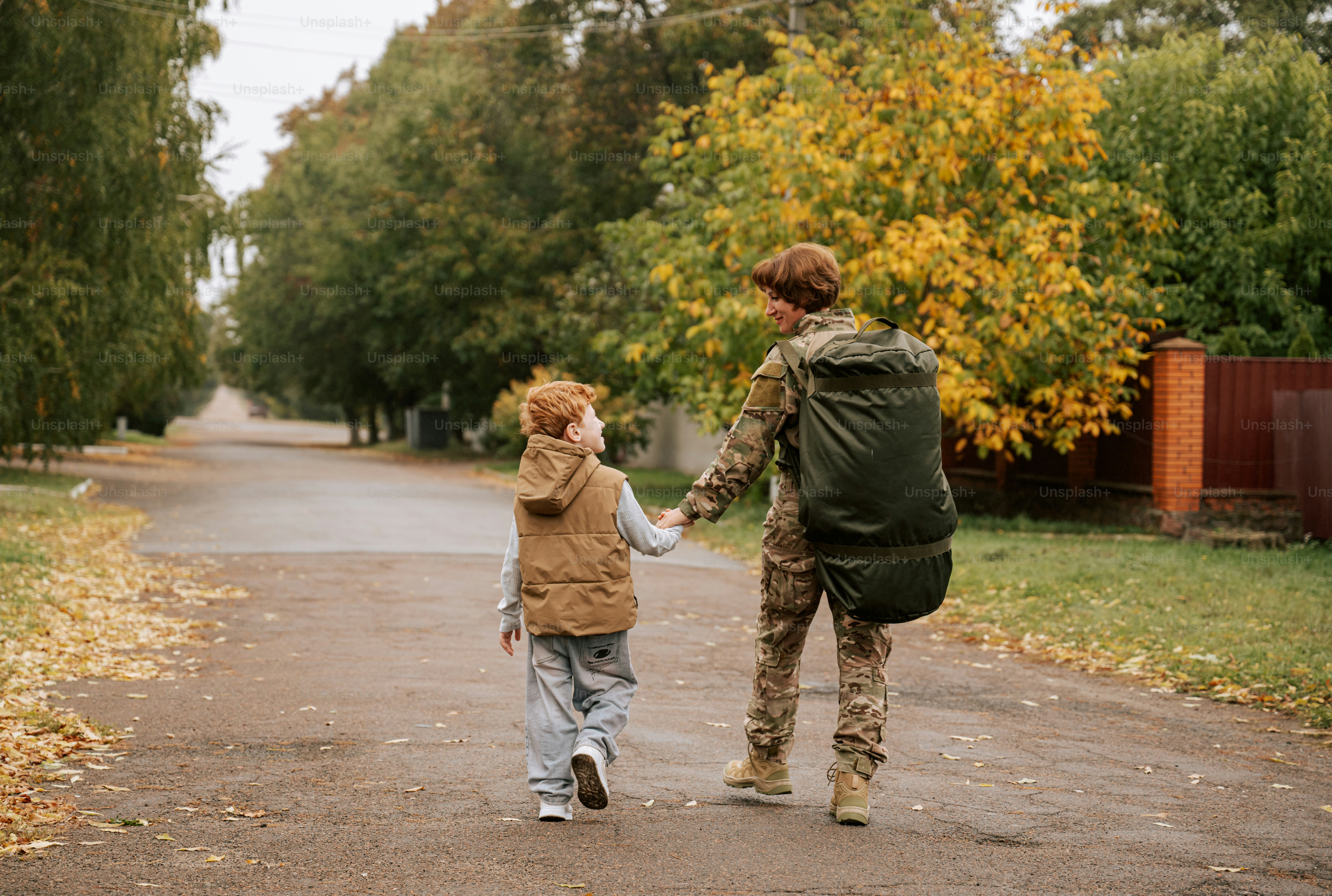 Woman in camouflage uniform holding child - Photo on Unsplash+