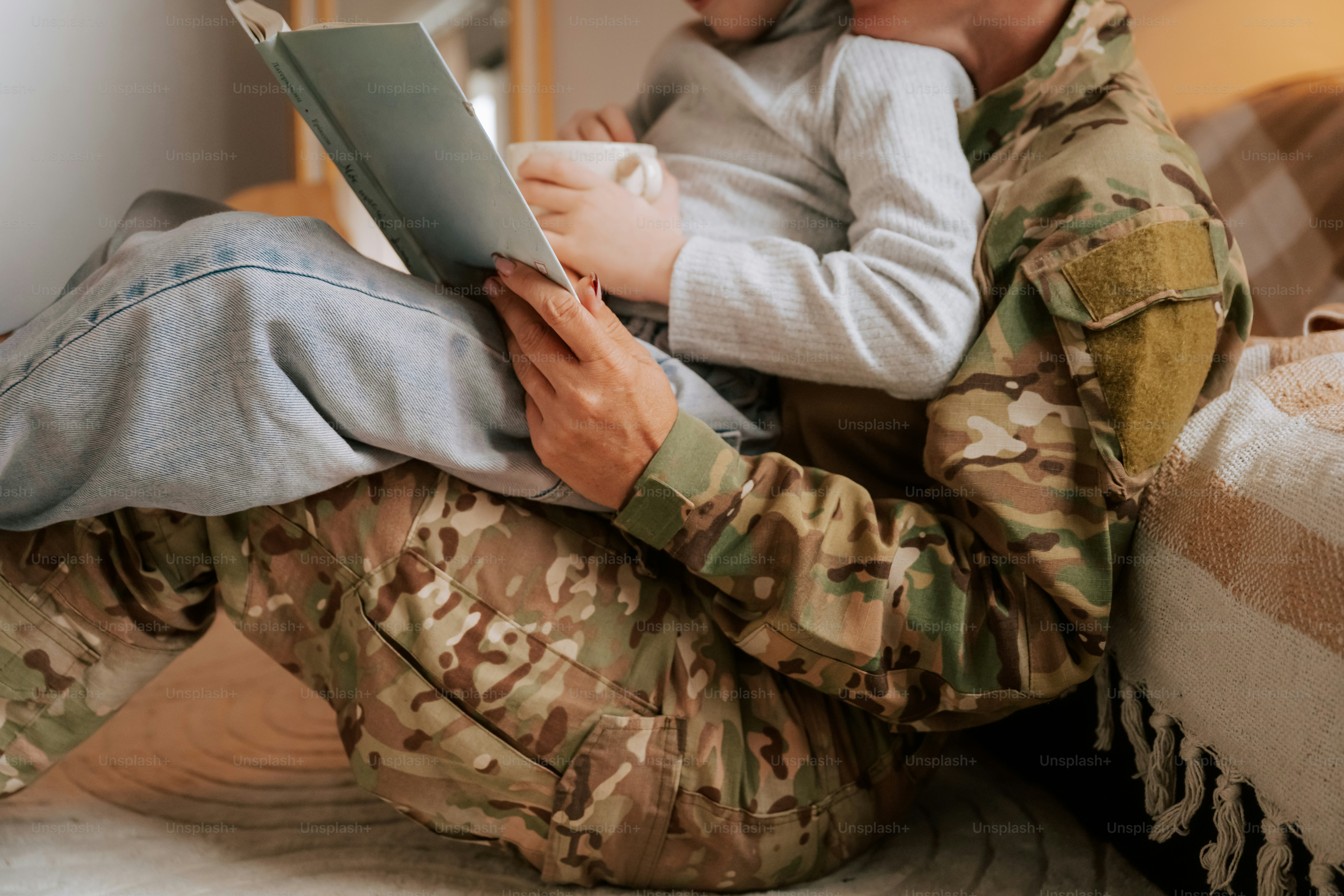Child hugging person in military uniform - Photo on Unsplash+