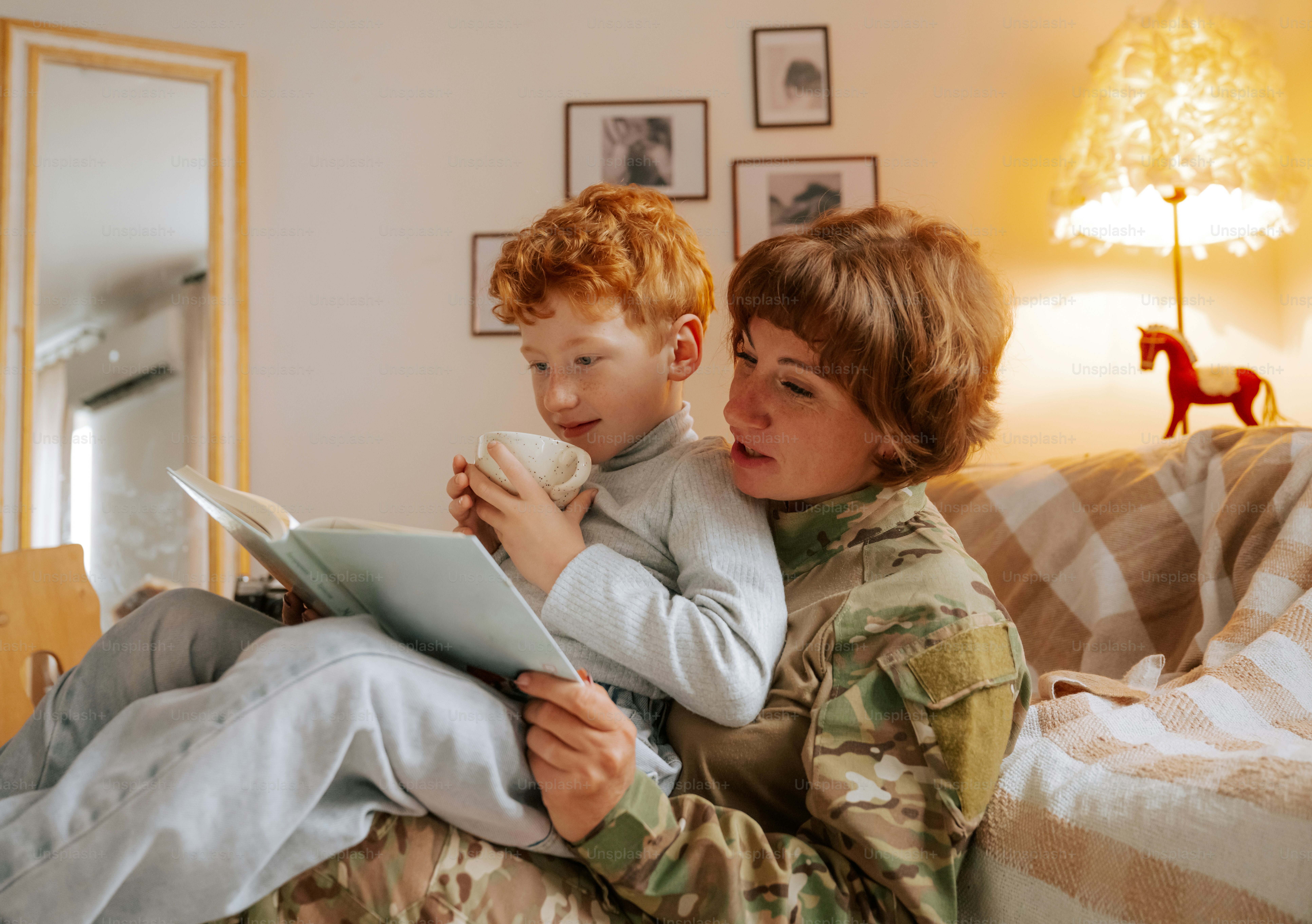 Woman in camouflage uniform holding child - Photo on Unsplash+