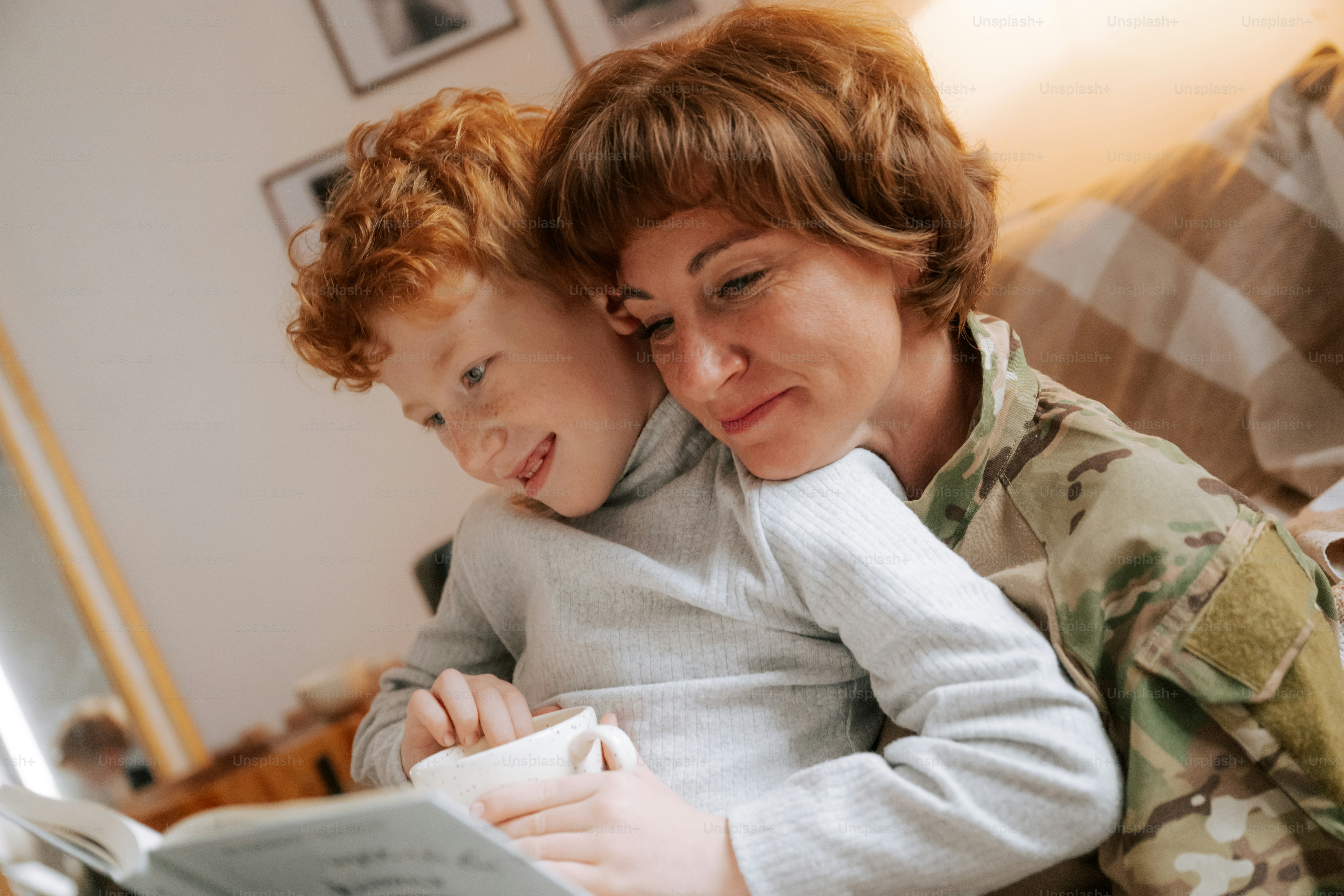 Woman in camouflage reading to child - Photo on Unsplash+