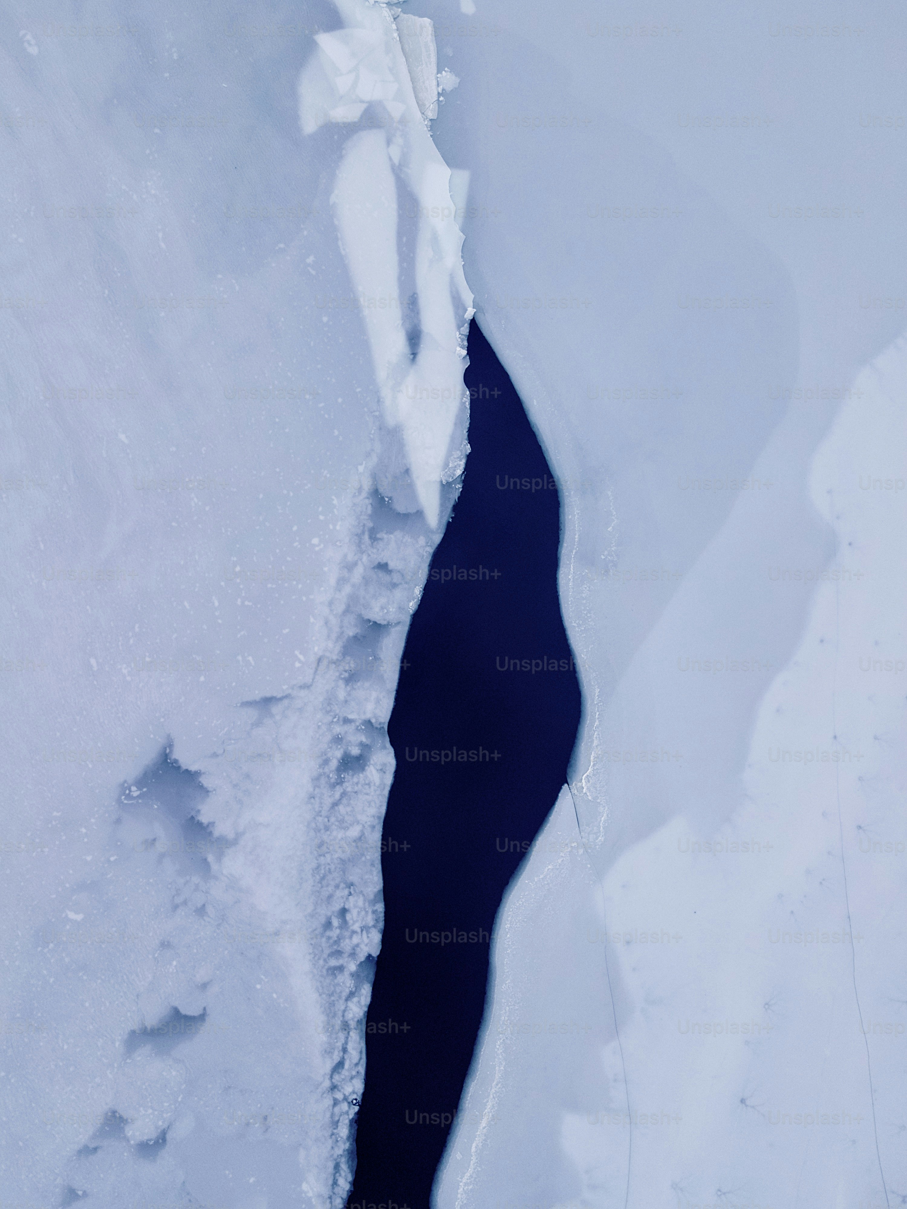Dark blue crack in white ice - Photo on Unsplash+