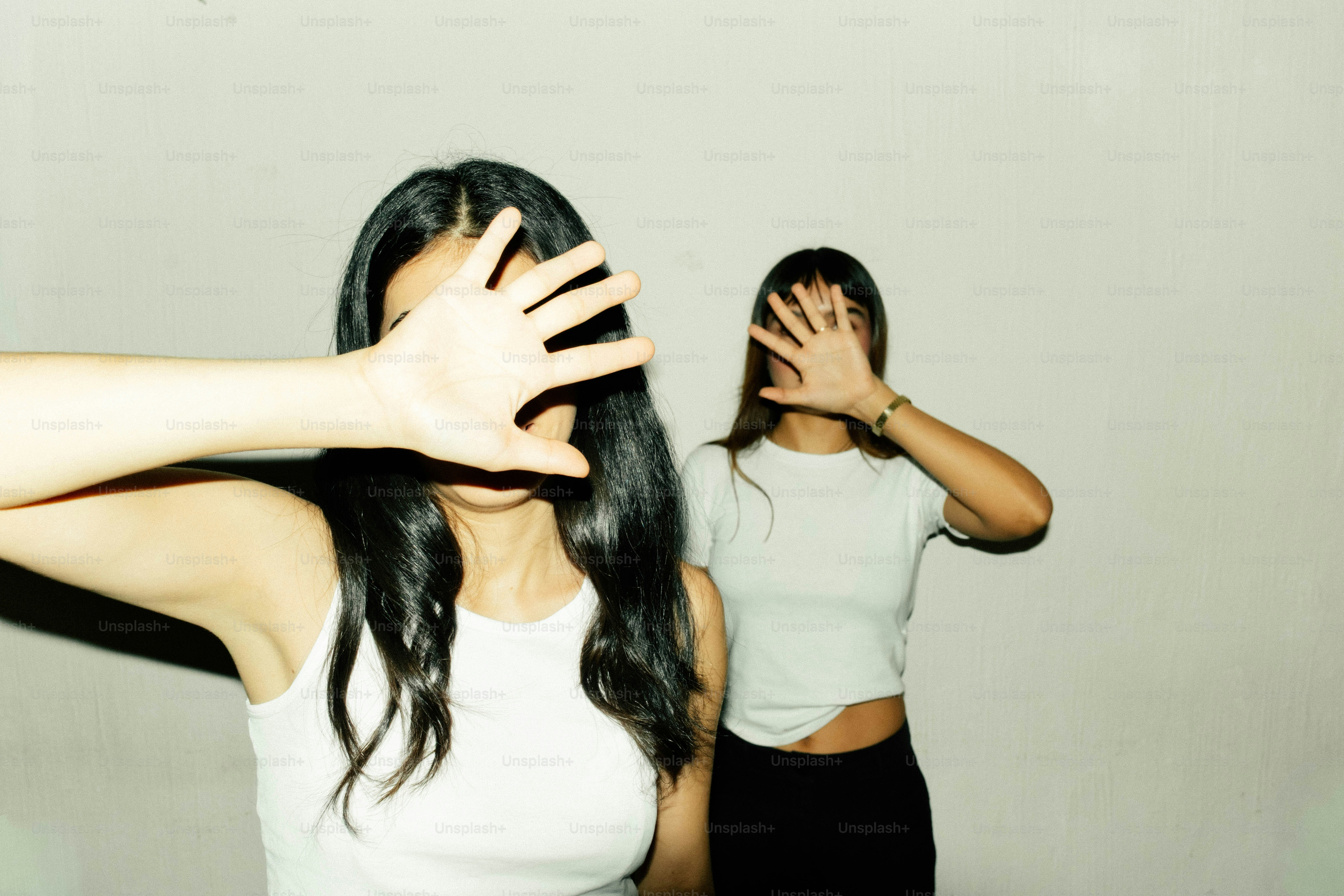 Two people covering faces with hands - Photo on Unsplash+