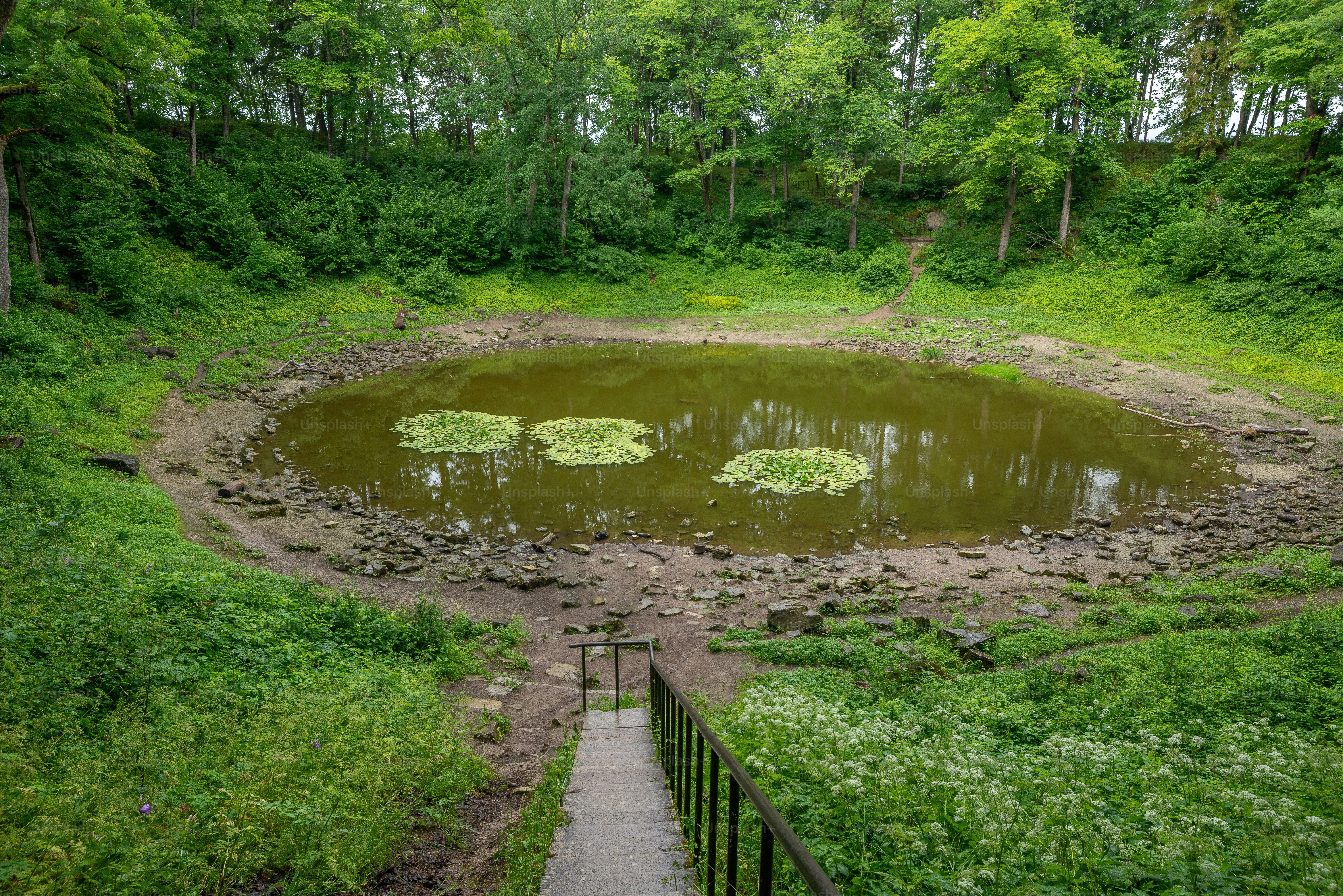 Kaali Crater lake with stone stairs - Photo on Unsplash+