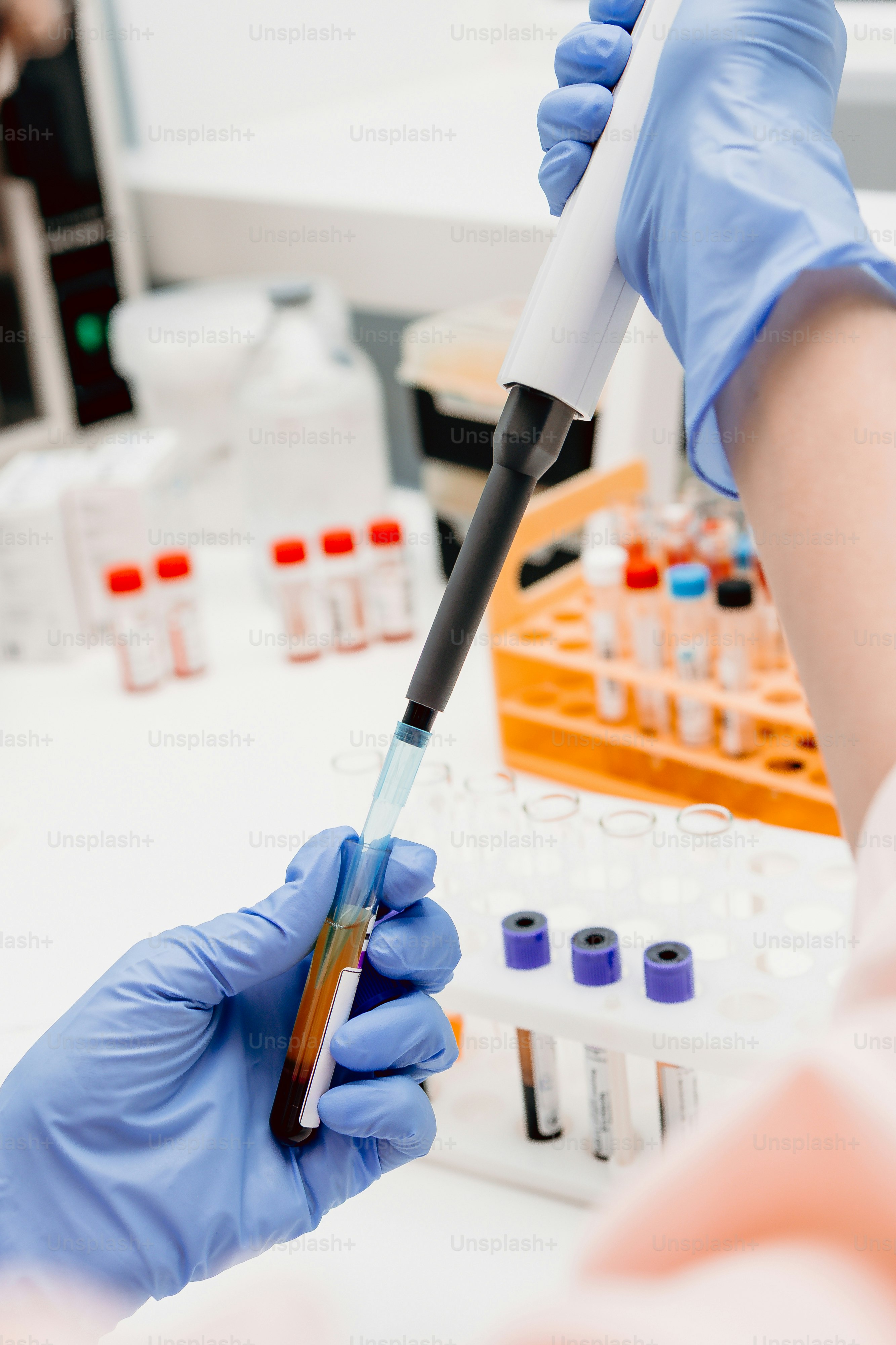 Person placing test tubes in centrifuge - Photo on Unsplash+