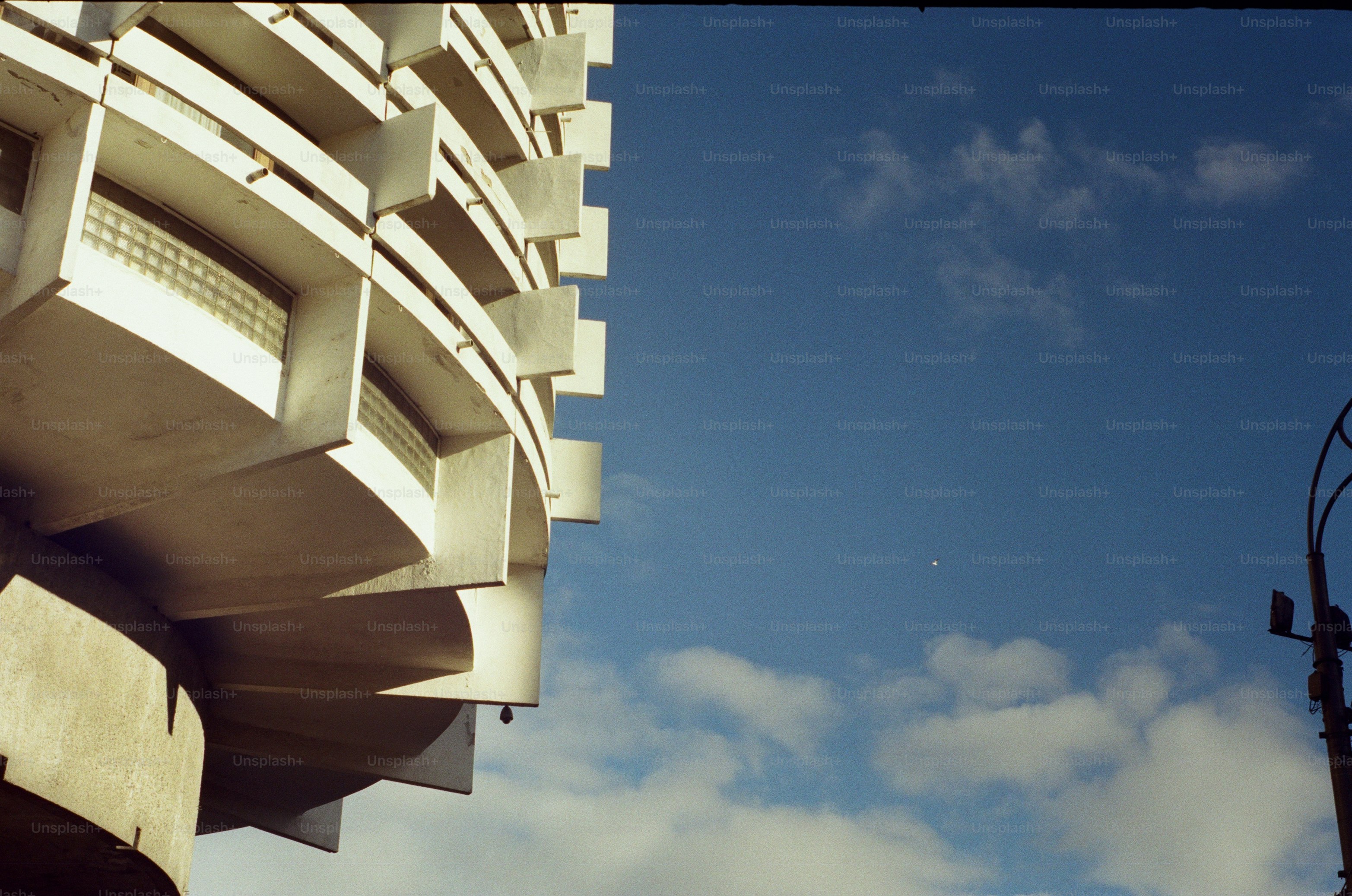 Curved white building with balconies - Photo on Unsplash+