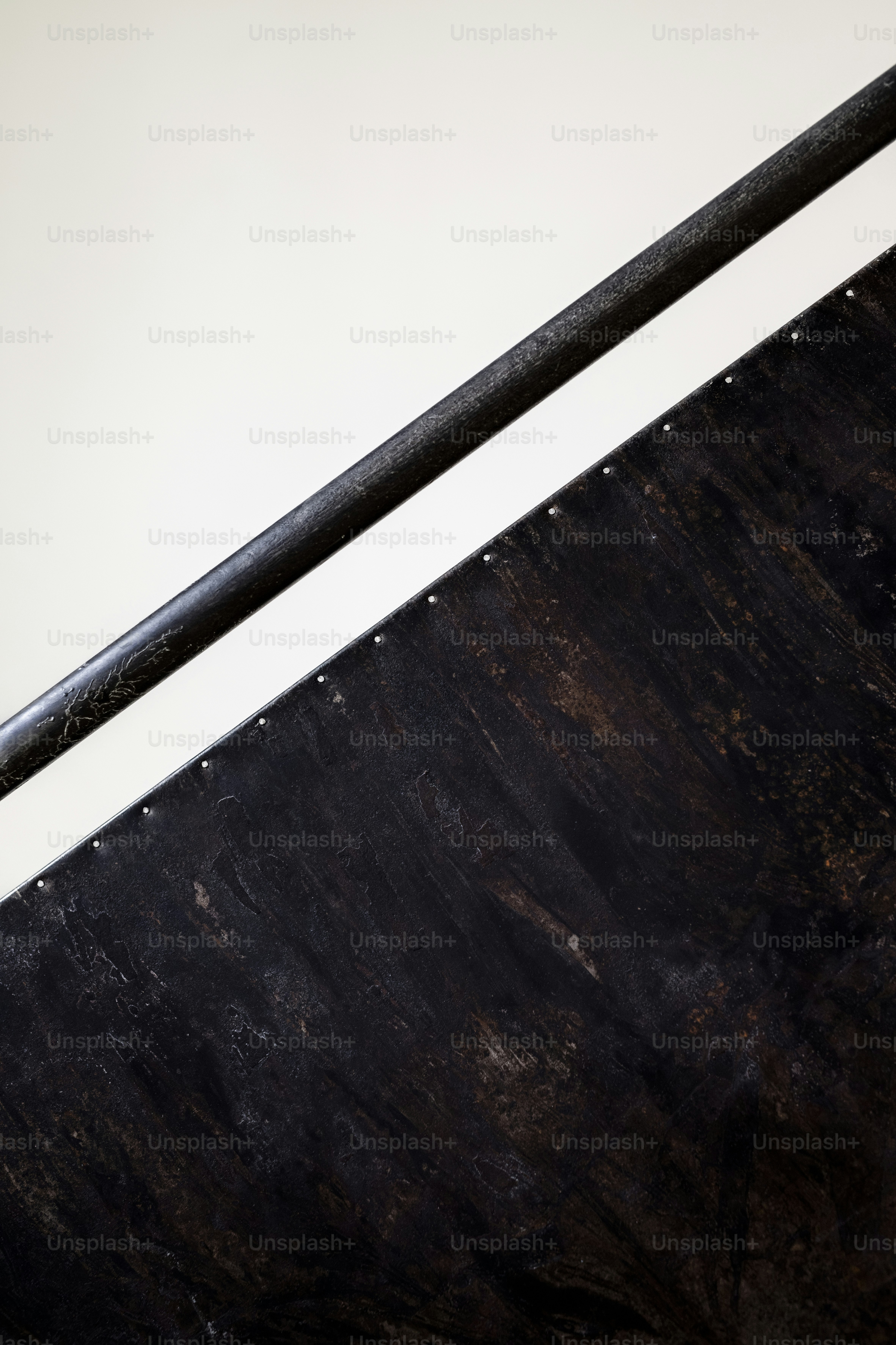 Dark metal panel with rivets - Photo on Unsplash+
