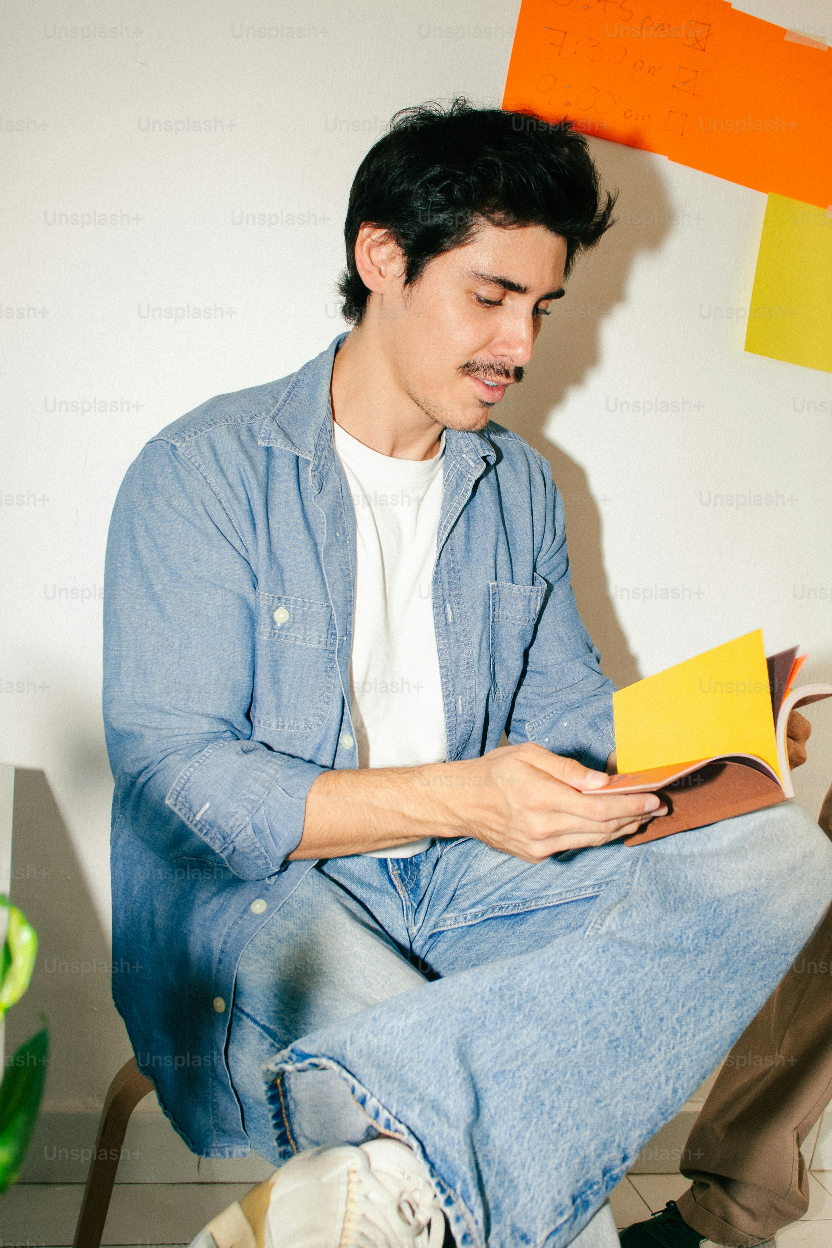 Man reading book in denim shirt - Photo on Unsplash+