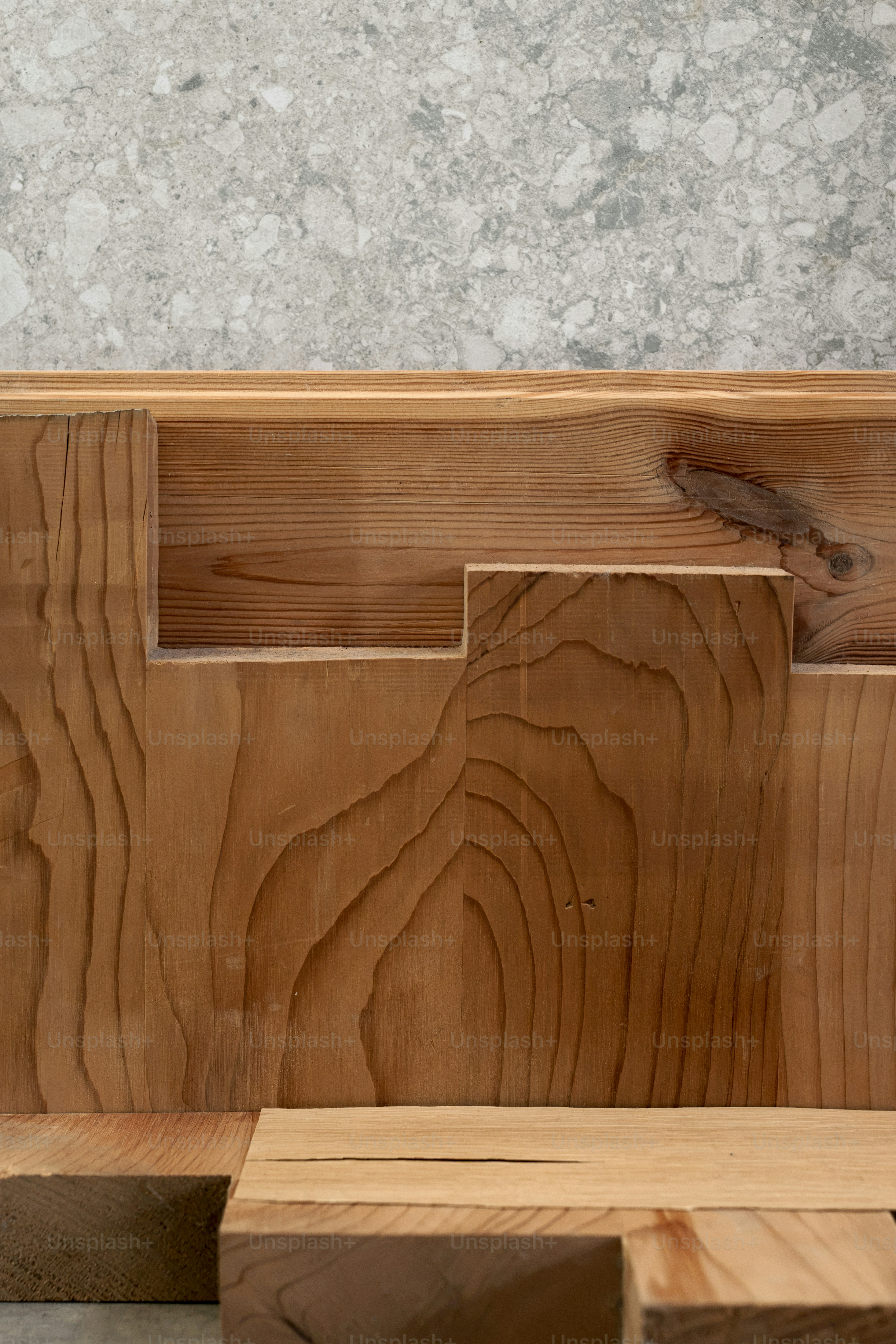 Layered wooden planks against concrete wall - Photo on Unsplash+