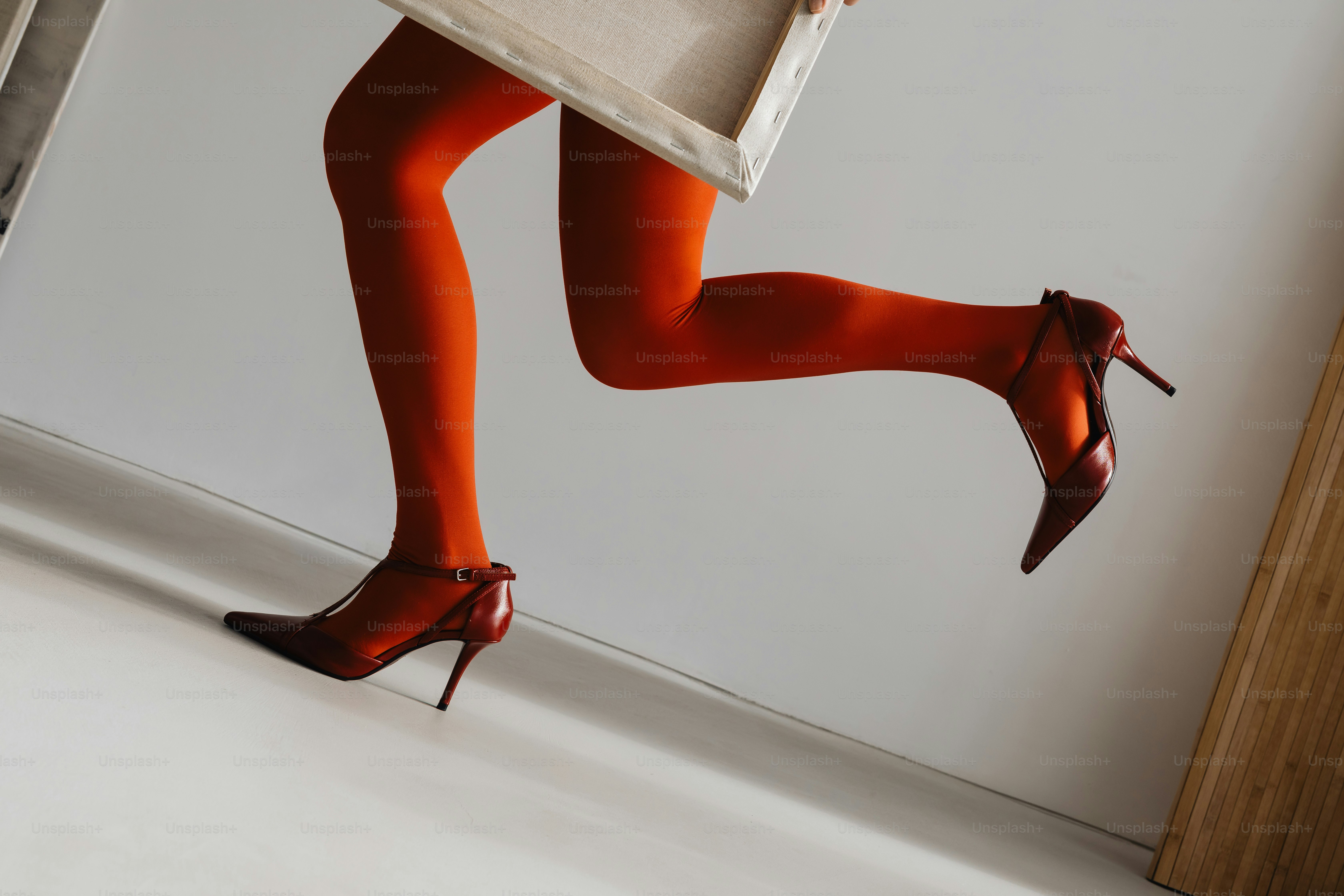 Leg in orange tights and heel - Photo on Unsplash+