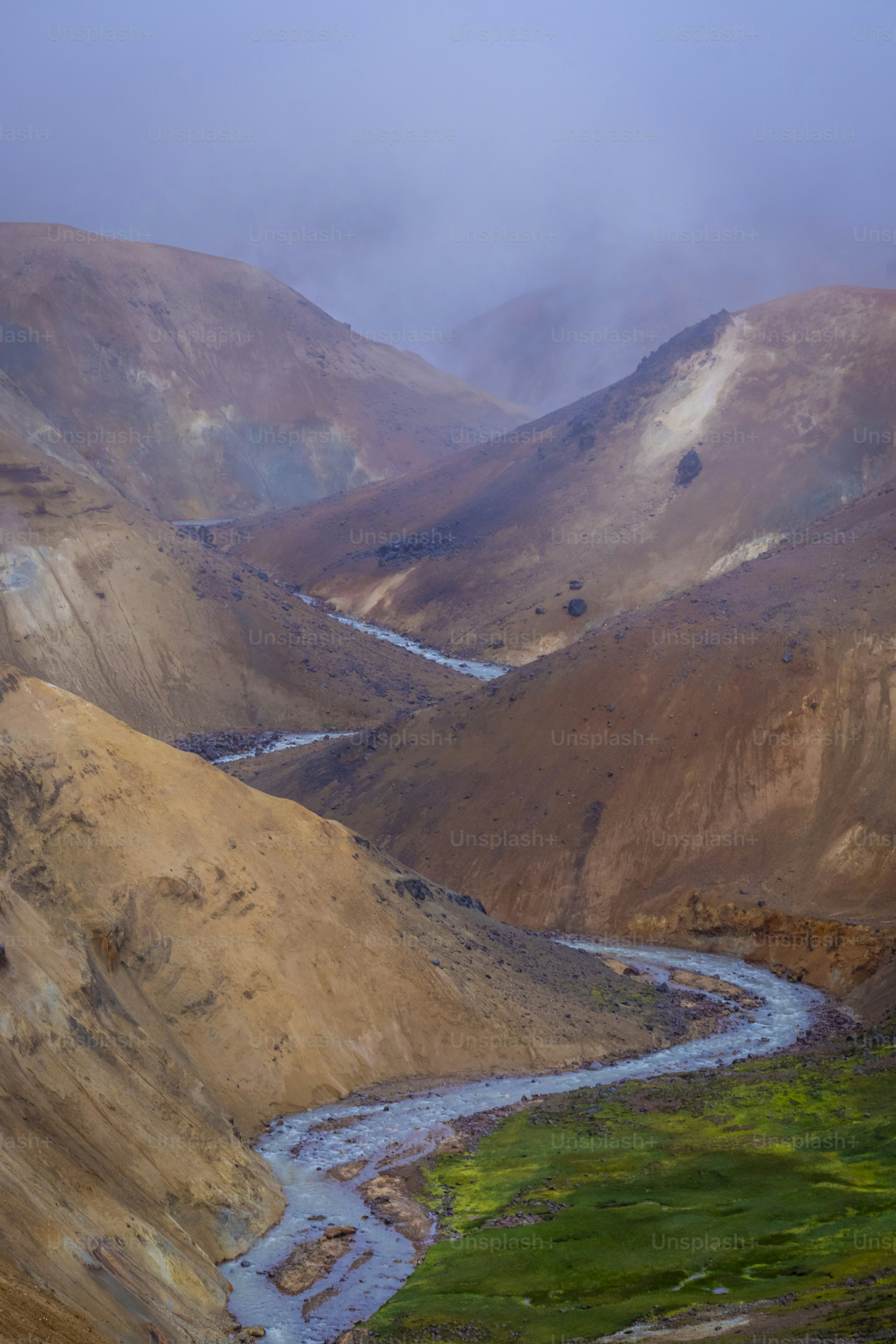 Winding river through brown mountain valley - Photo on Unsplash+