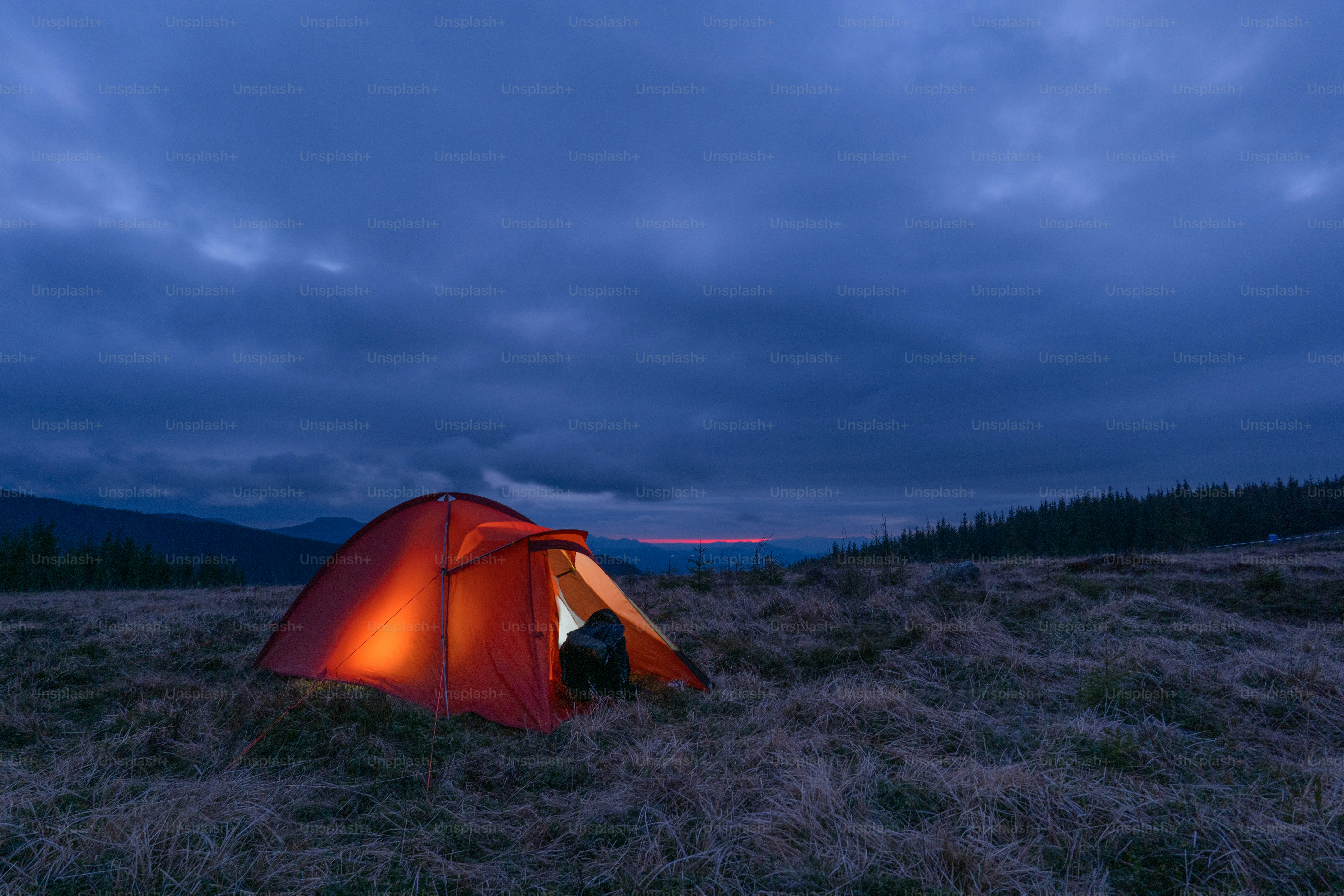 Orange tent in mountain landscape - Photo on Unsplash+