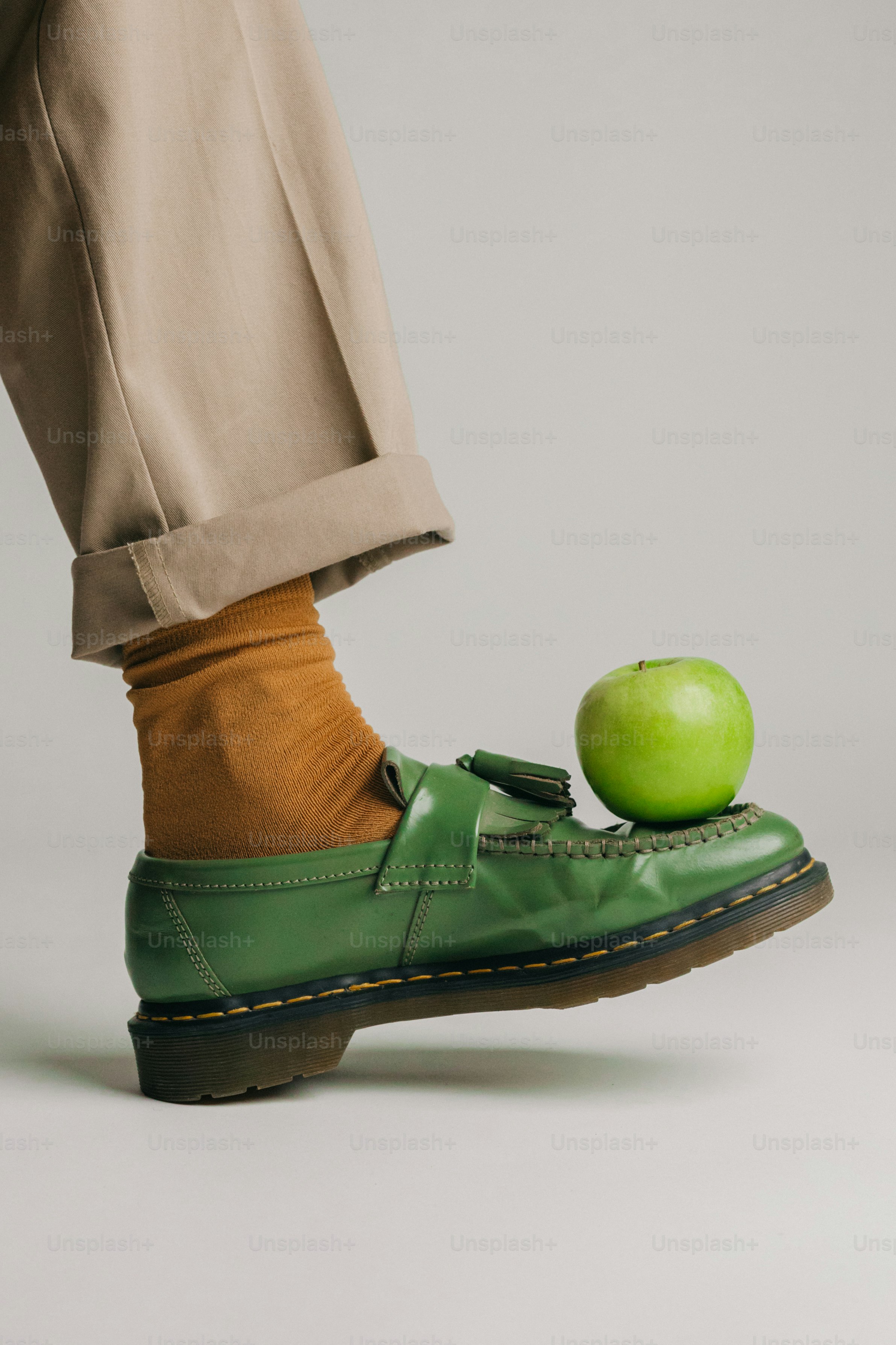 Manzana verde sobre mocasín de cuero - Foto en Unsplash+