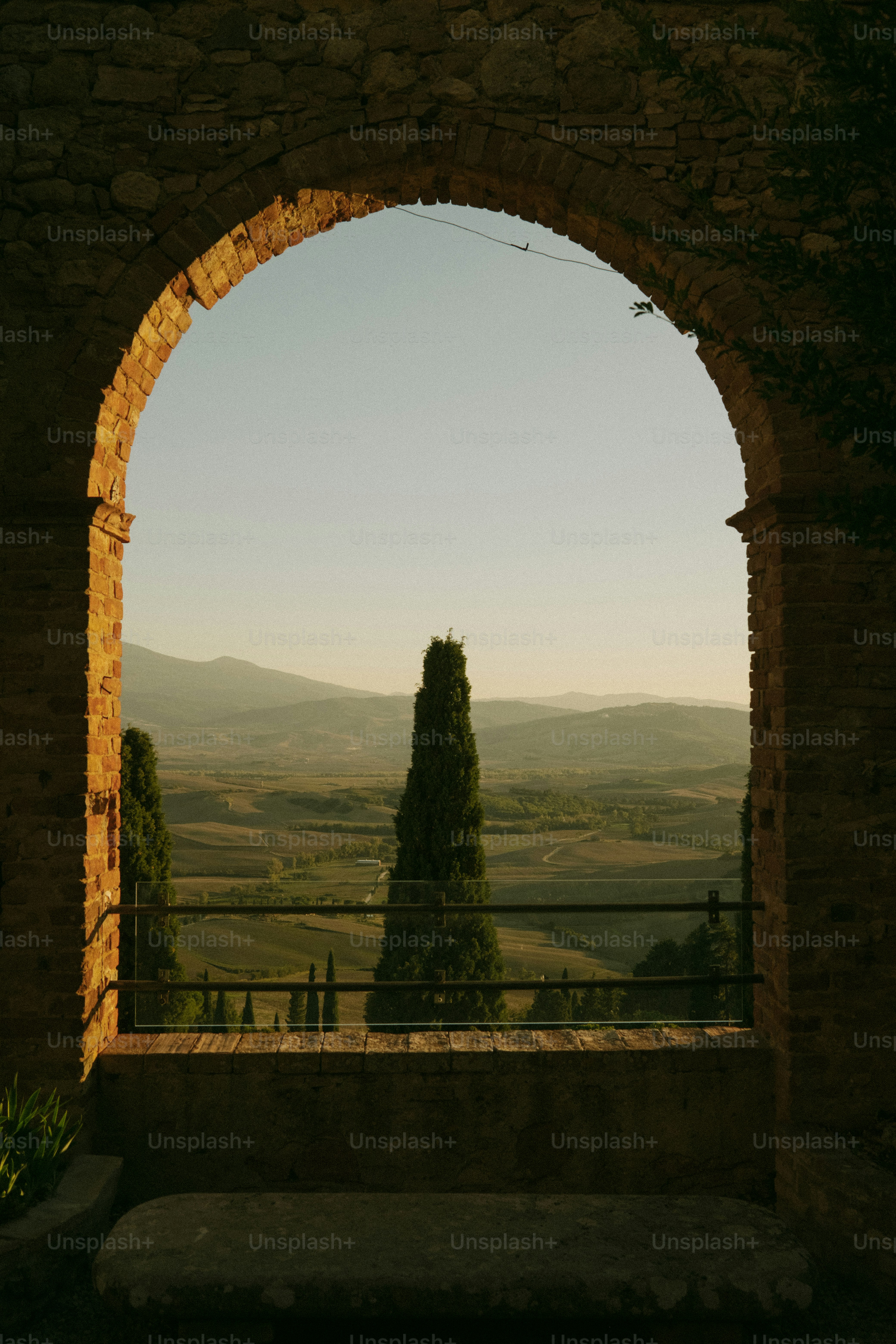 Brick archway overlooking Pienza hills - Photo on Unsplash+