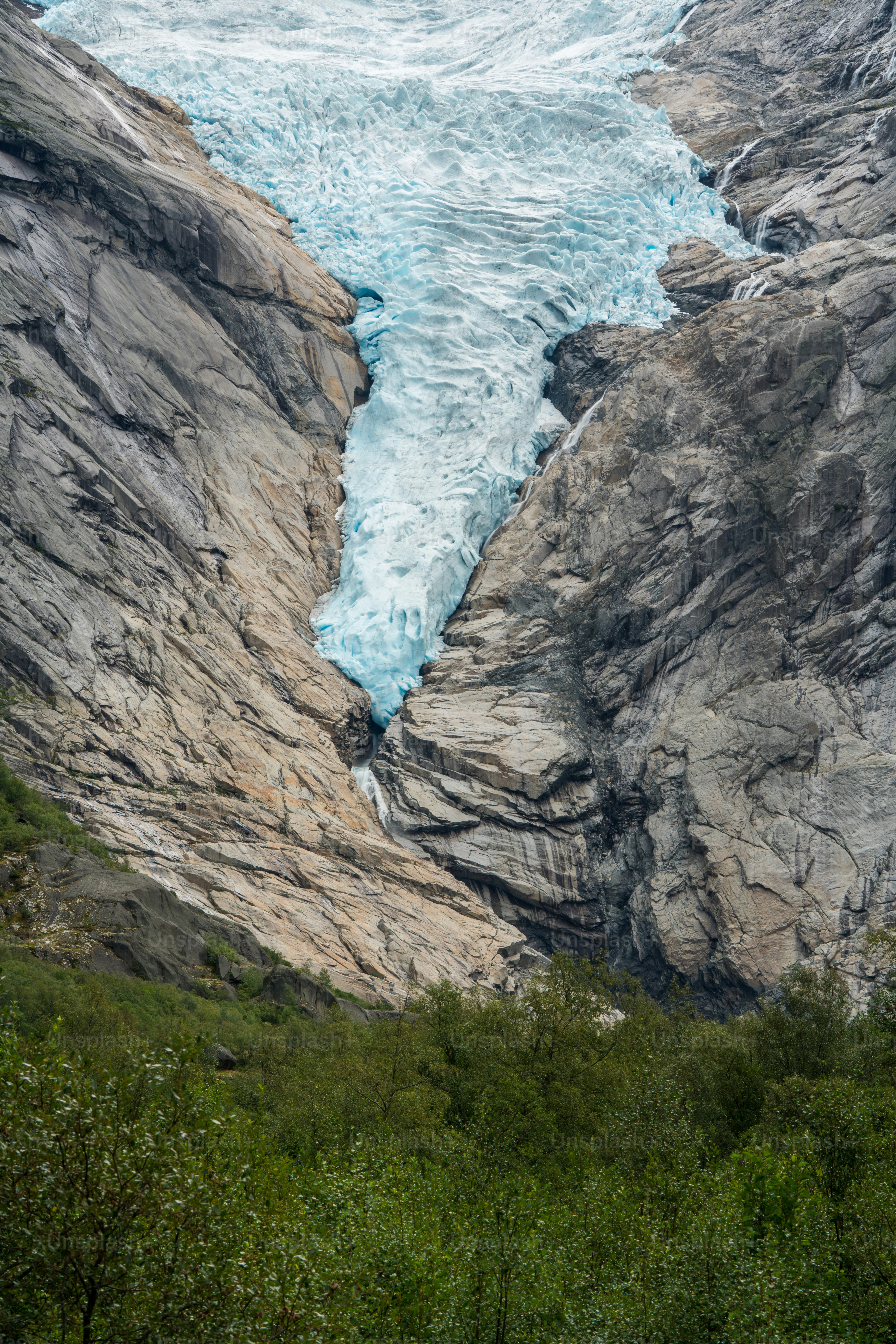 Blue glacier between steep rocky cliffs - Photo on Unsplash+