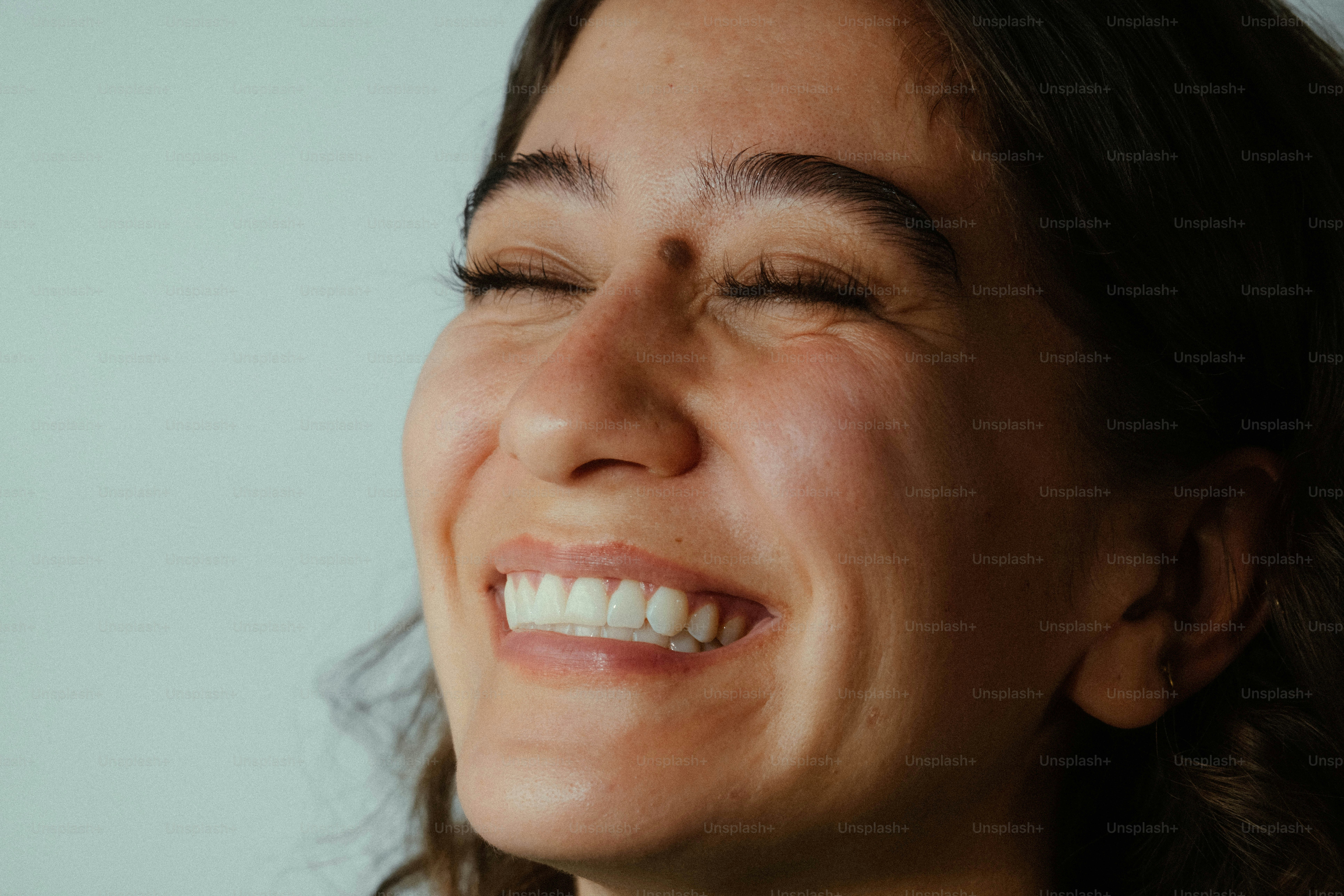 Woman smiling with closed eyes - Photo on Unsplash+