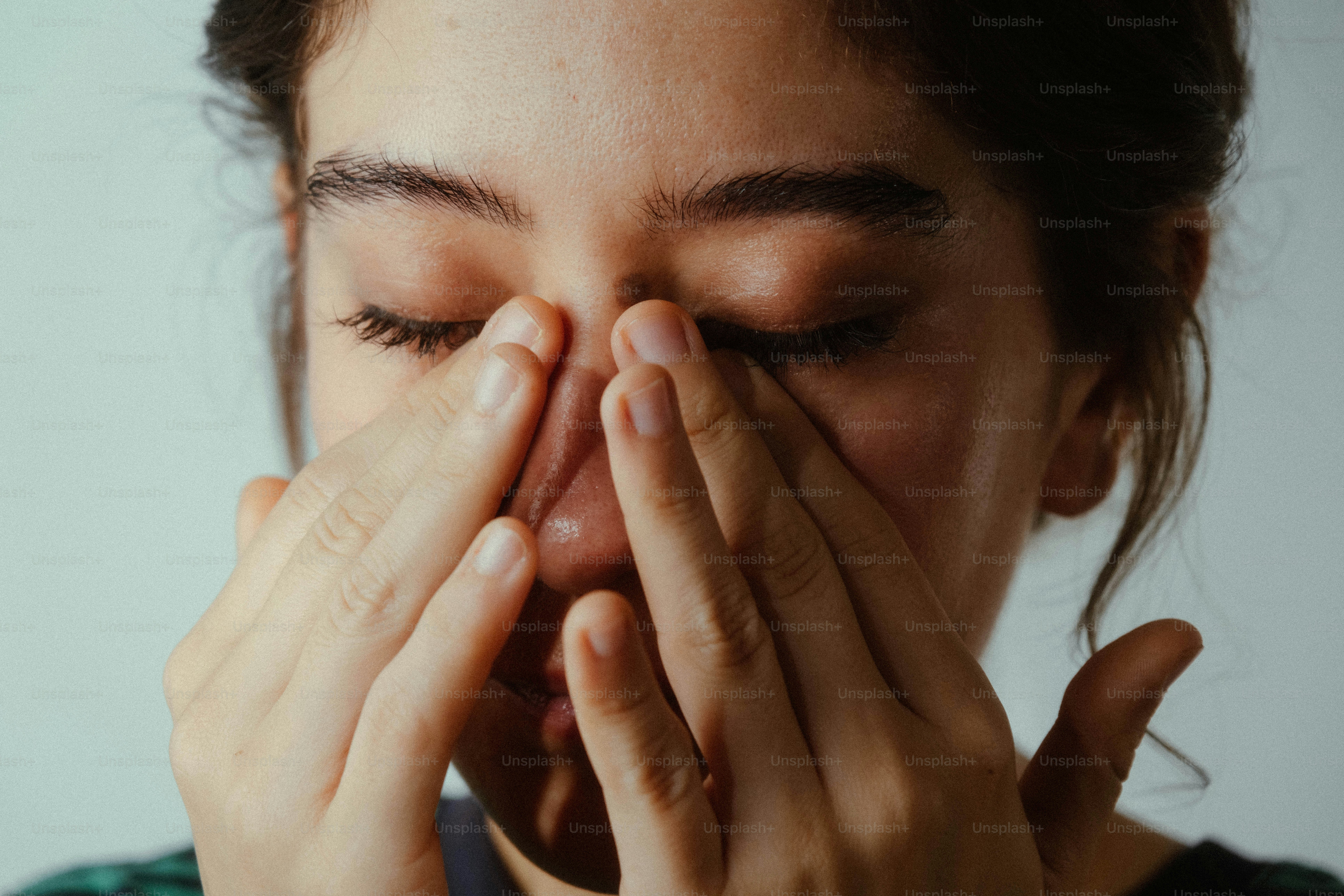 Person pressing bridge of nose - Photo on Unsplash+