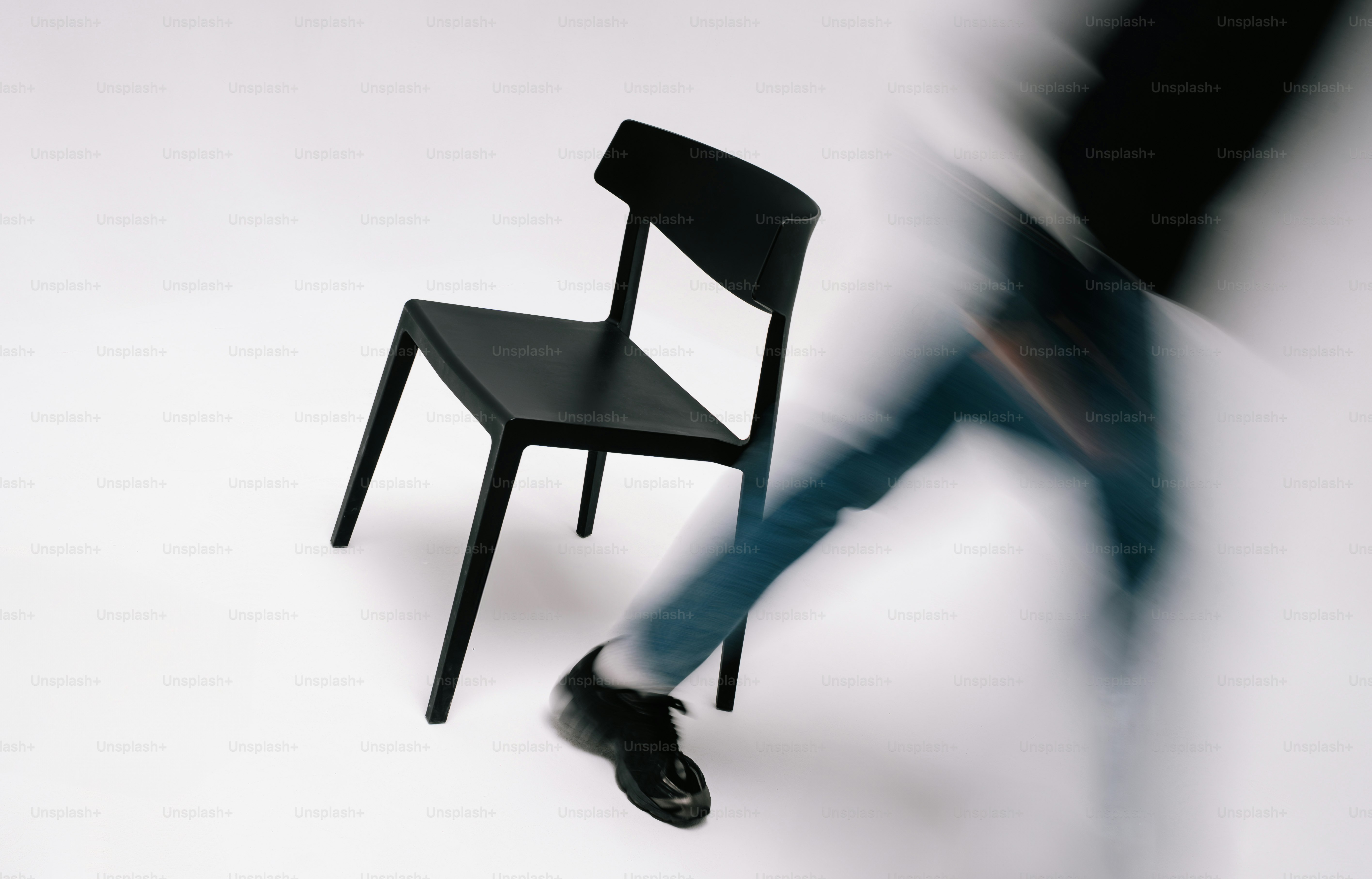 Person walking past black office chair - Photo on Unsplash+